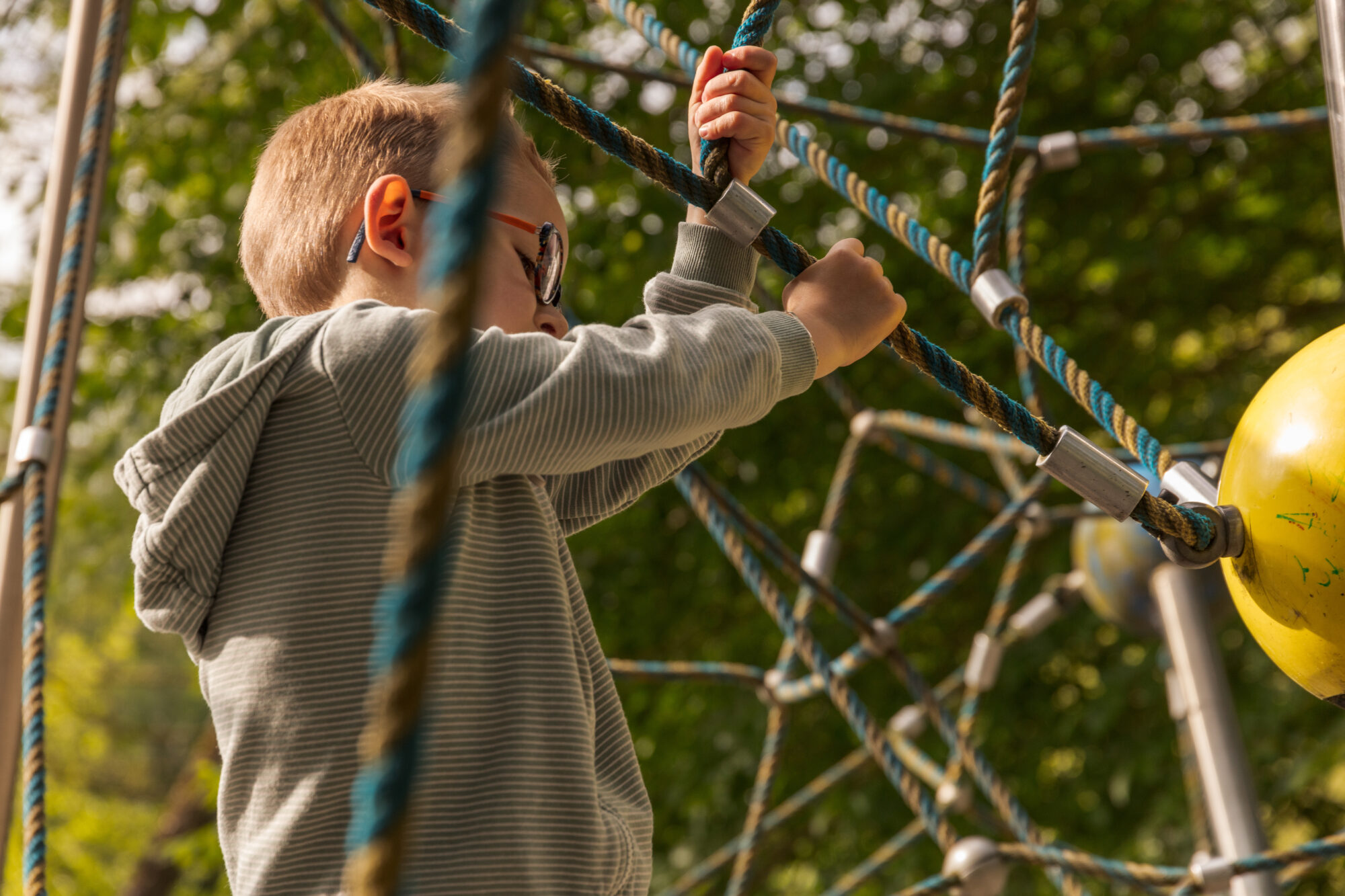 Enfant grimpant sur un filet de jeux, Office de Tourisme Cœur de Garonne