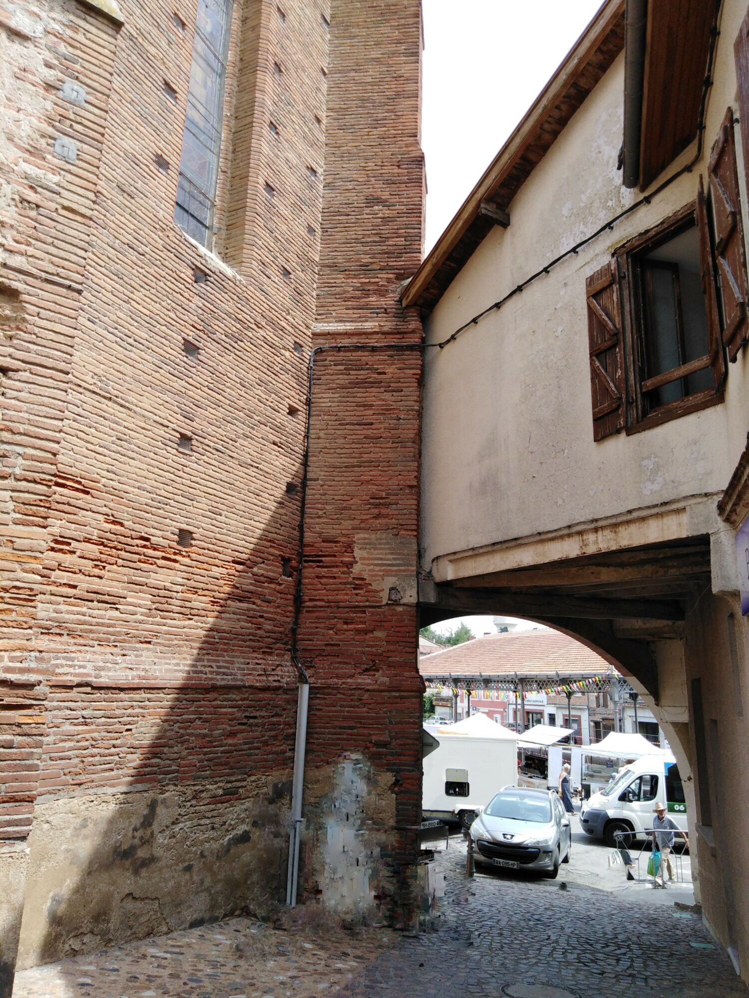 Passage voûté entre mur en brique et maison à colombage à Cœur de Garonne