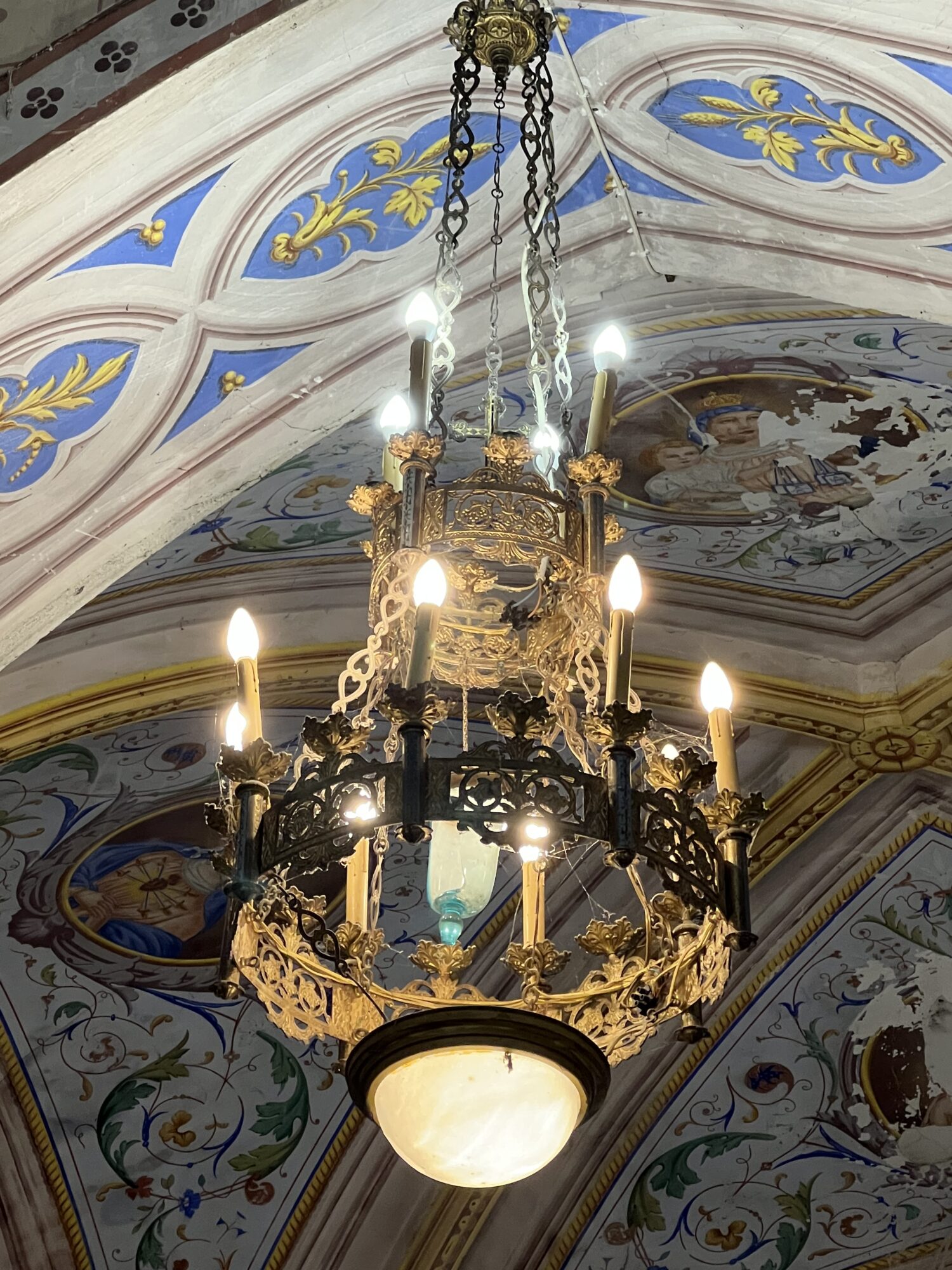 Lustre ancien suspendu sous une voûte peinte d’église