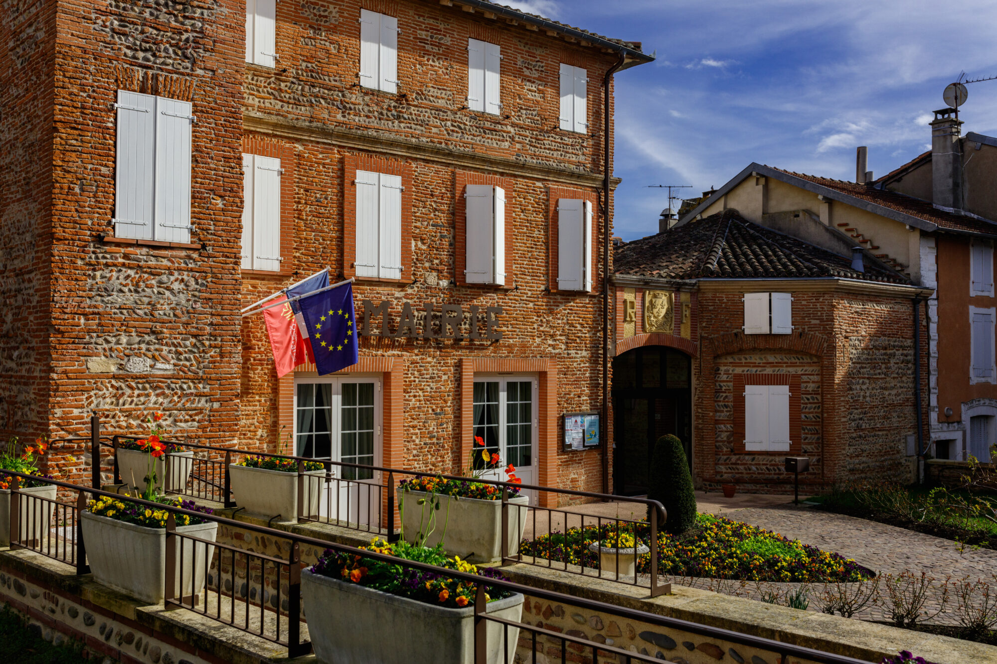 Mairie en brique avec drapeaux, Office de Tourisme Cœur de Garonne