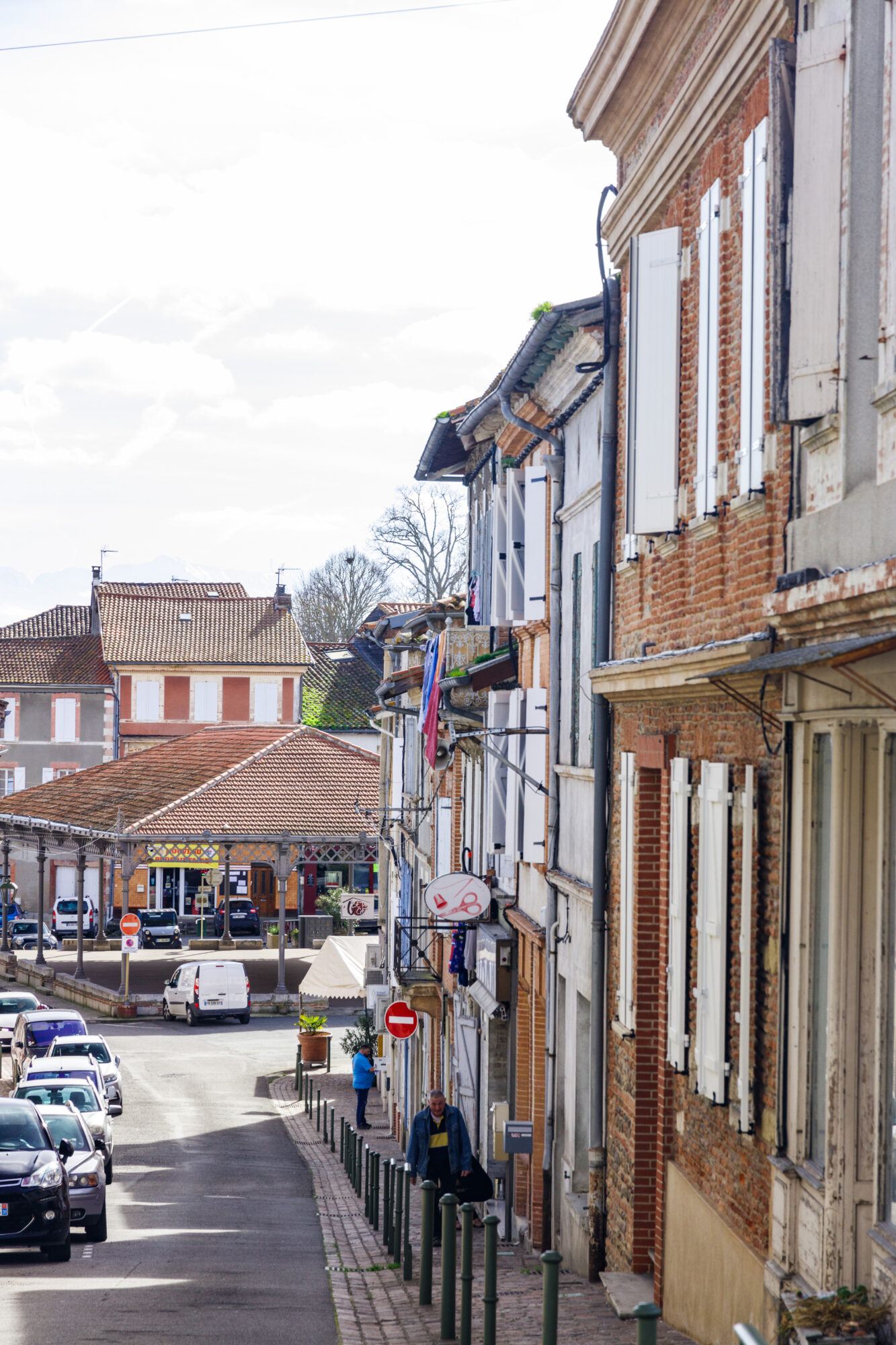 Rue de village et maisons à volets près de la halle couverte