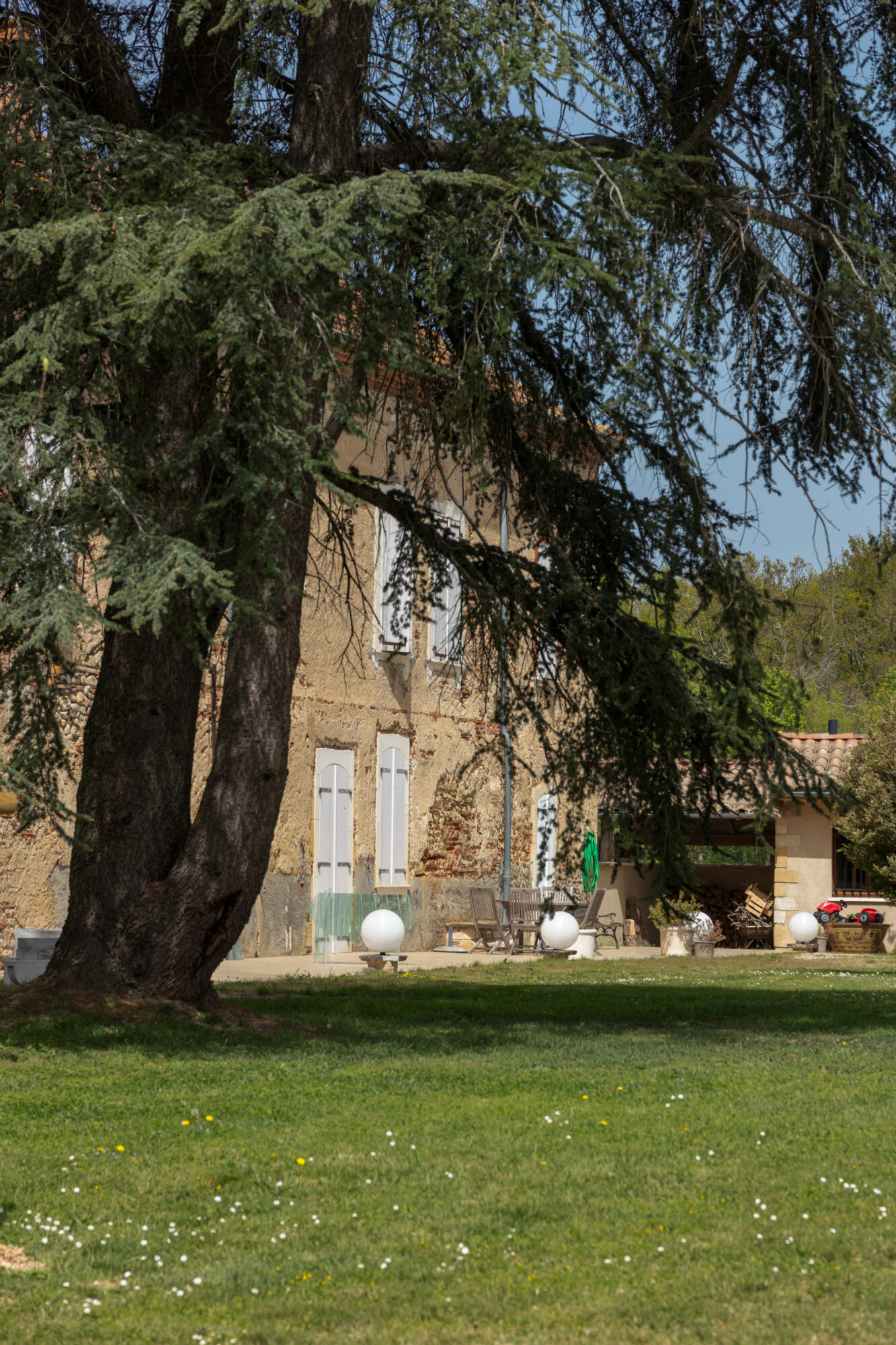 Maison de caractère vue derrière un grand cèdre, Office de Tourisme Cœur de