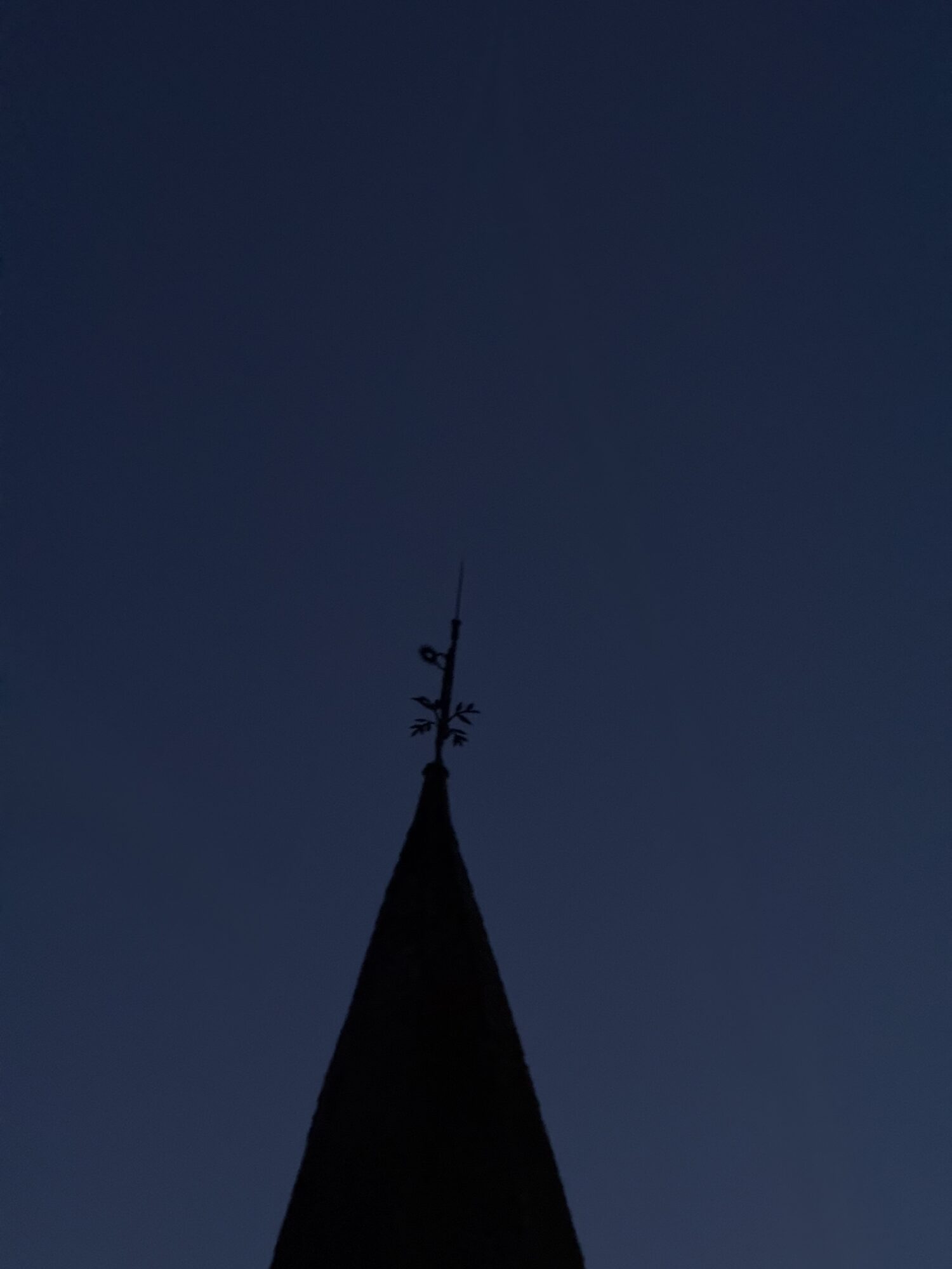 Flèche d’église en silhouette surmontée d’une girouette