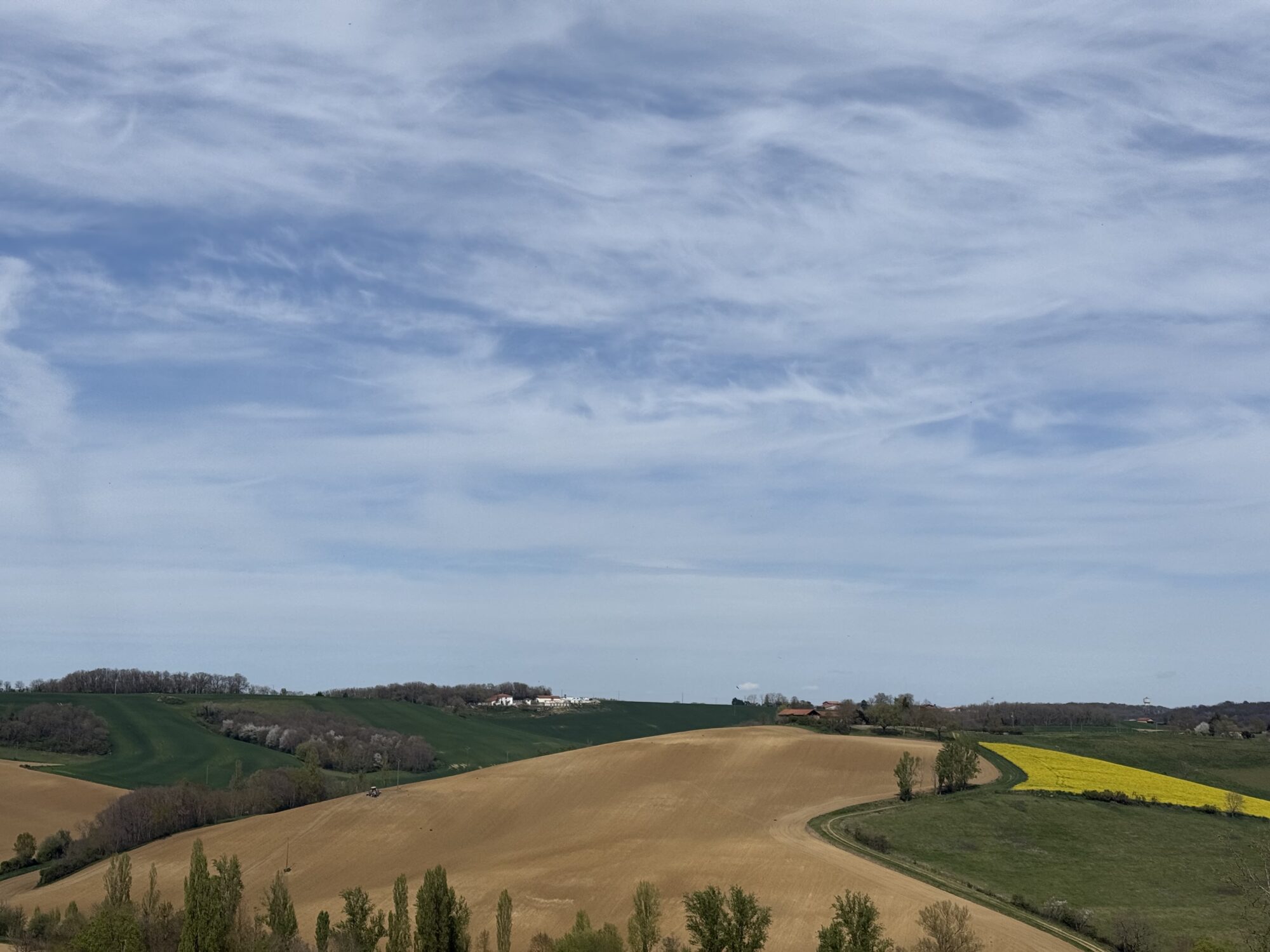 Paysage vallonné de champs cultivés en Cœur de Garonne