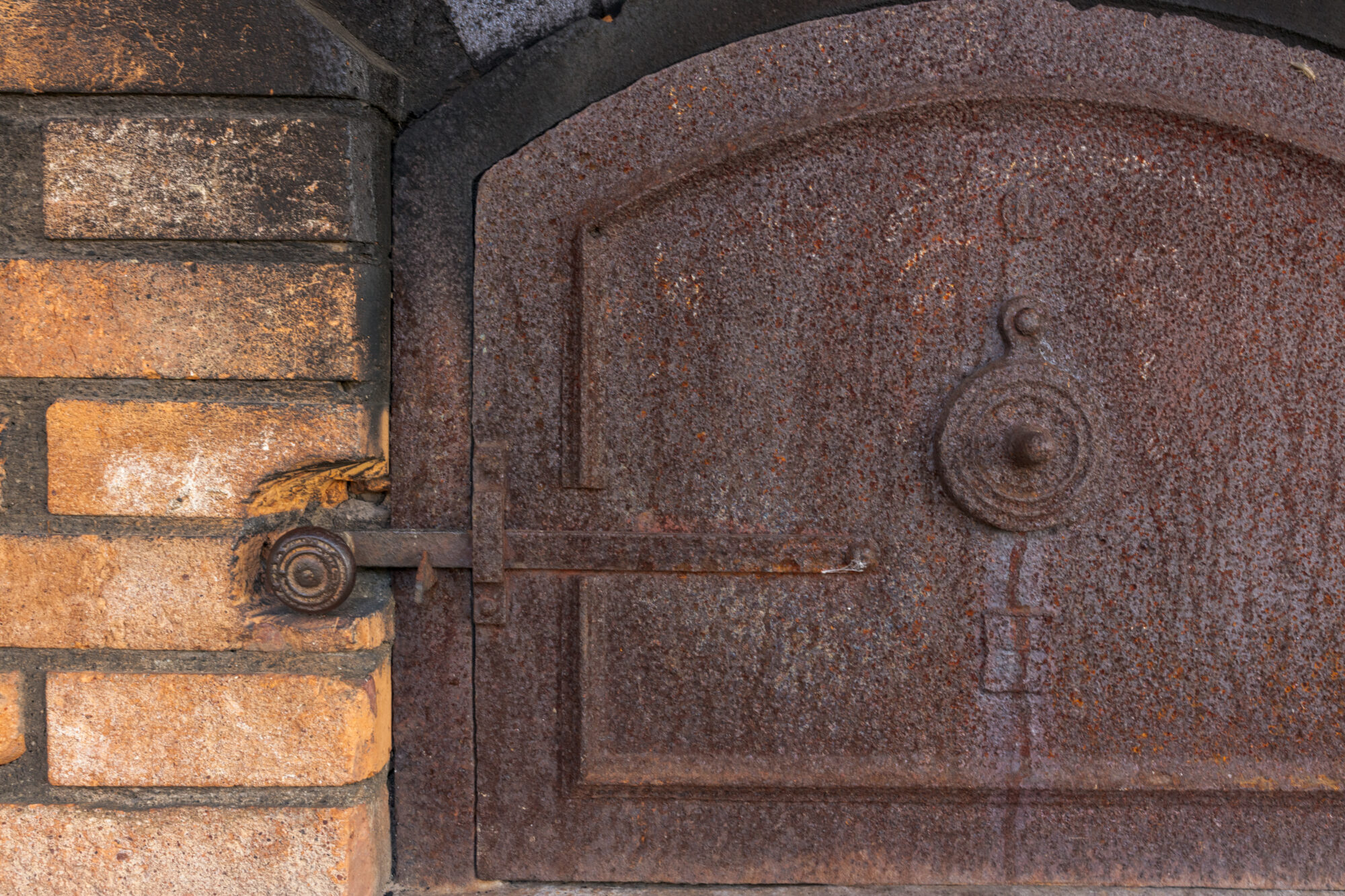 Porte de four en fonte rouillée avec loquet métallique ancien