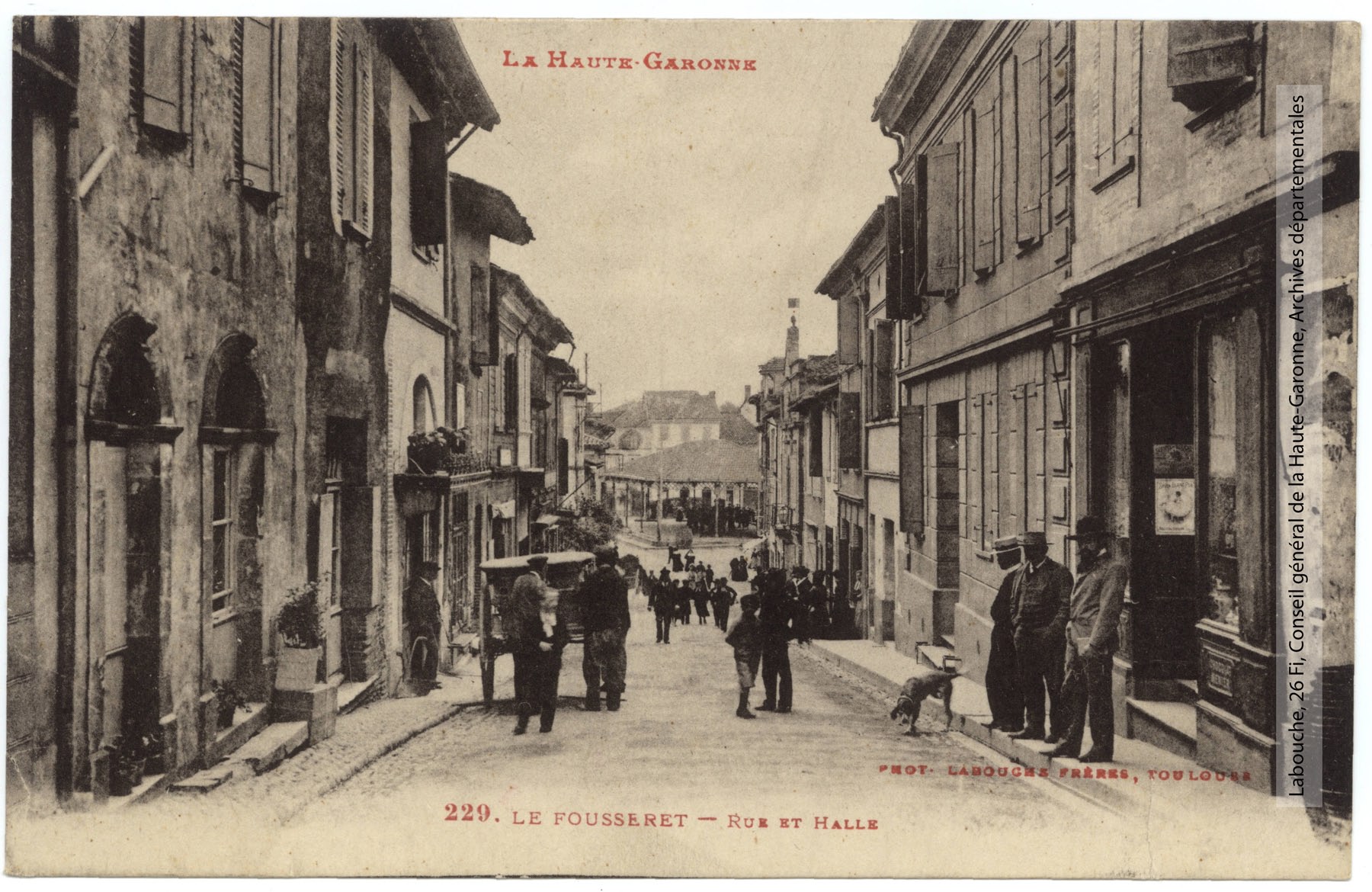 Carte postale ancienne du Fousseret, rue animée menant à la halle