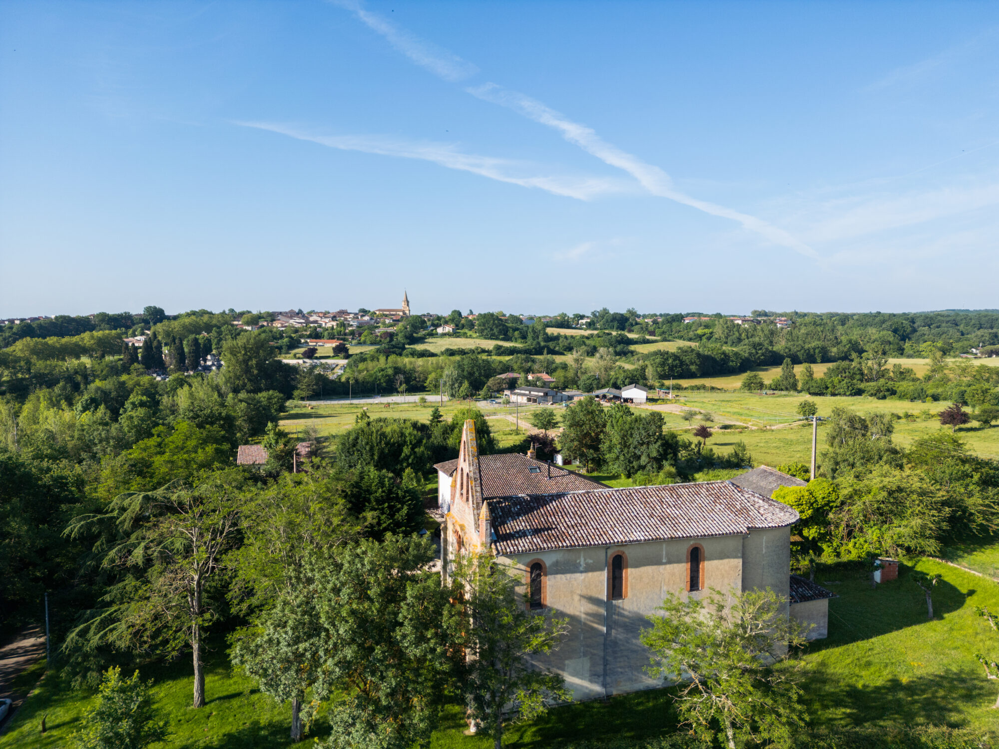 Vue sur une chapelle et le village en Cœur de Garonne
