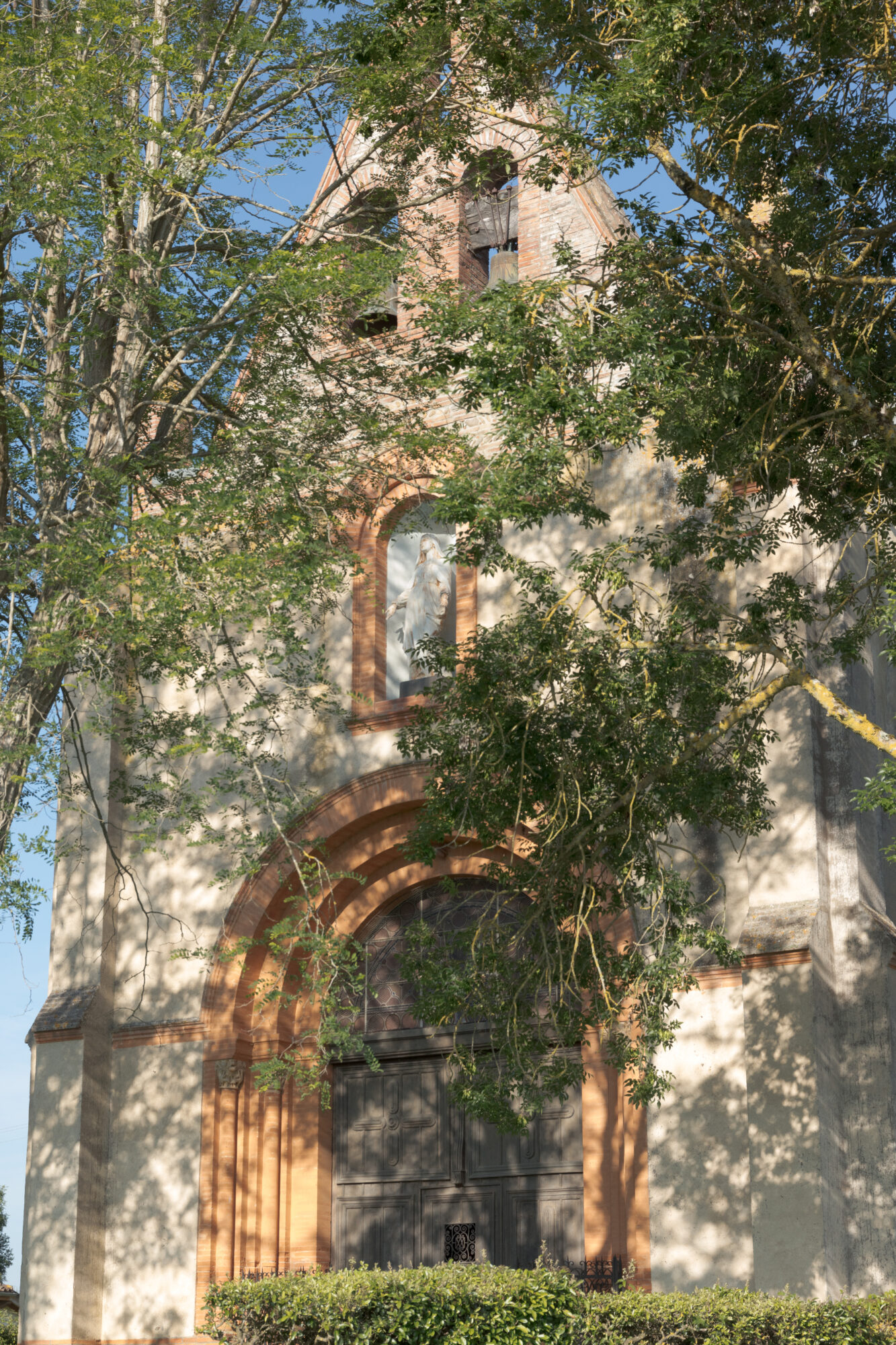 Façade d’église avec clocher et statue, Office de Tourisme Cœur de Garonne