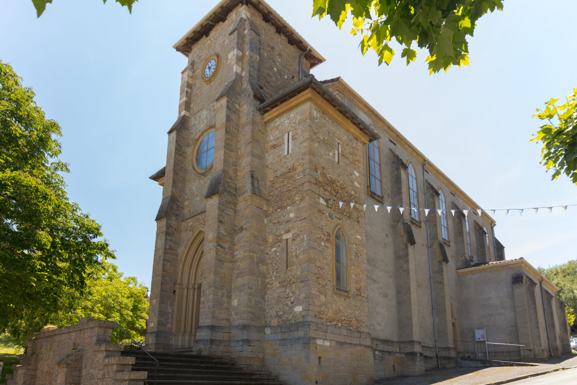 Église en pierre avec clocher et horloge en Cœur de Garonne
