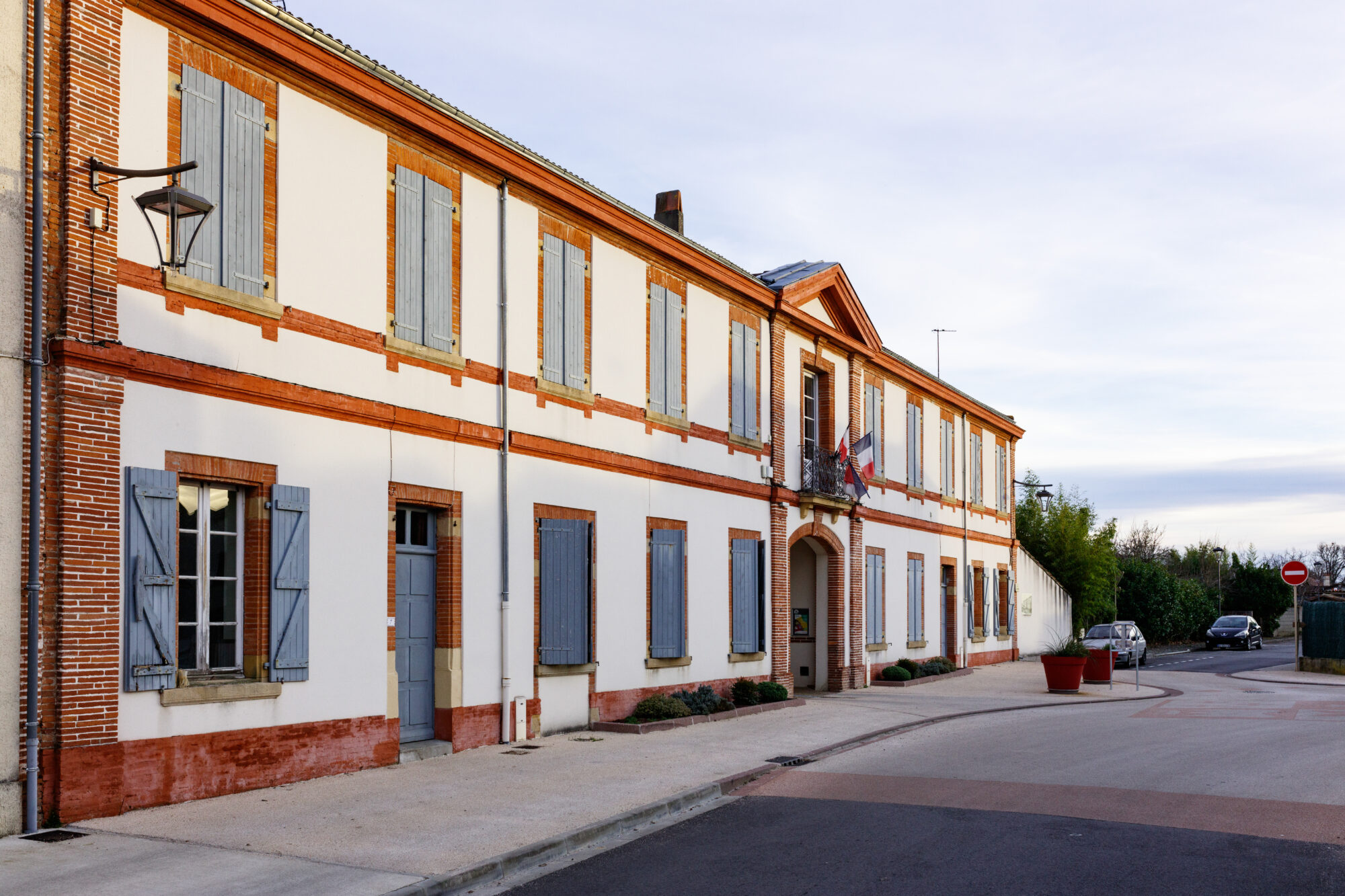 Façade de mairie en briques et volets bleus à Cœur de Garonne