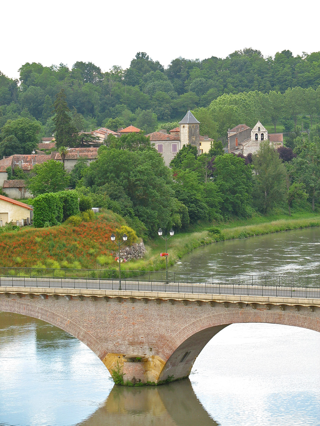 Pont en brique sur la Garonne devant un village de Cœur de Garonne
