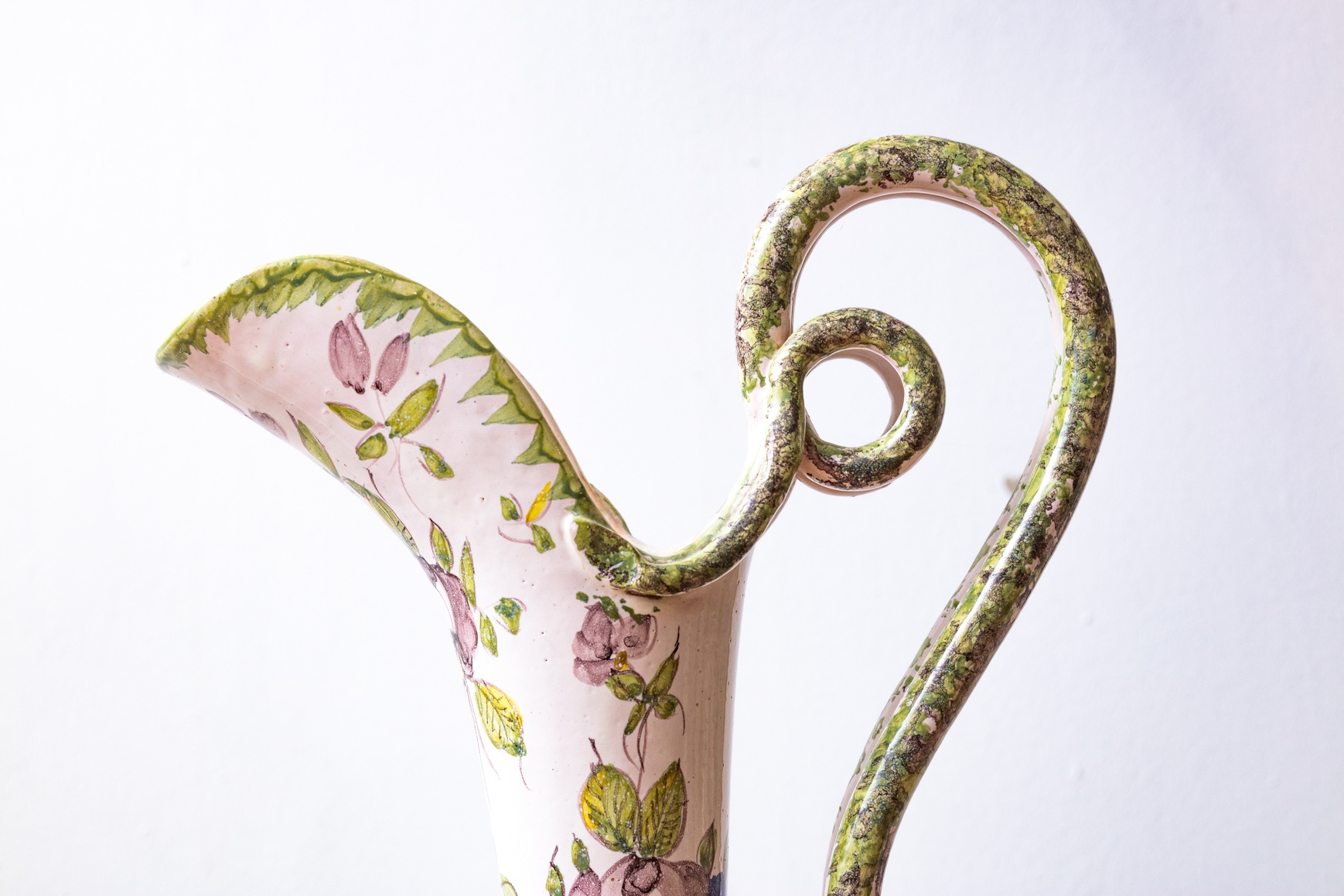 Pichet en céramique décoré de motifs floraux et anse en volute