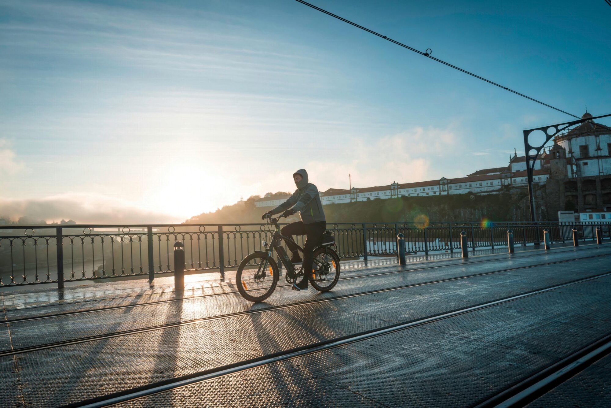 Cycliste traversant un pont en ville au lever du soleil