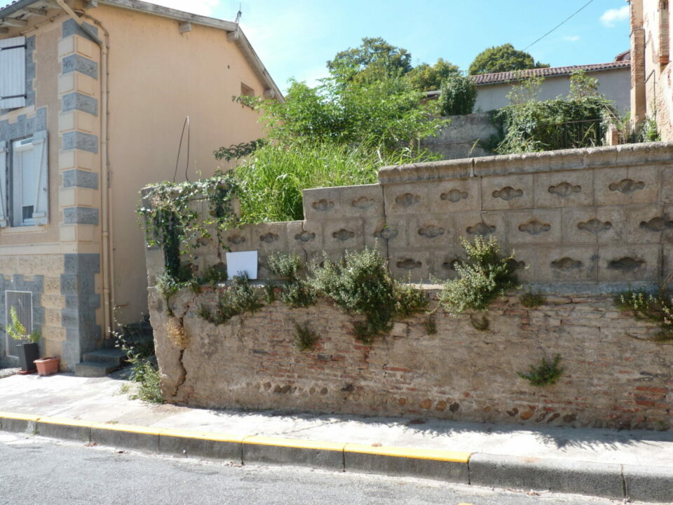 Maison et mur en pierre au bord de rue à Cœur de Garonne