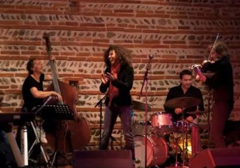 Groupe de jazz en concert, chanteuse, contrebasse, batterie et violon