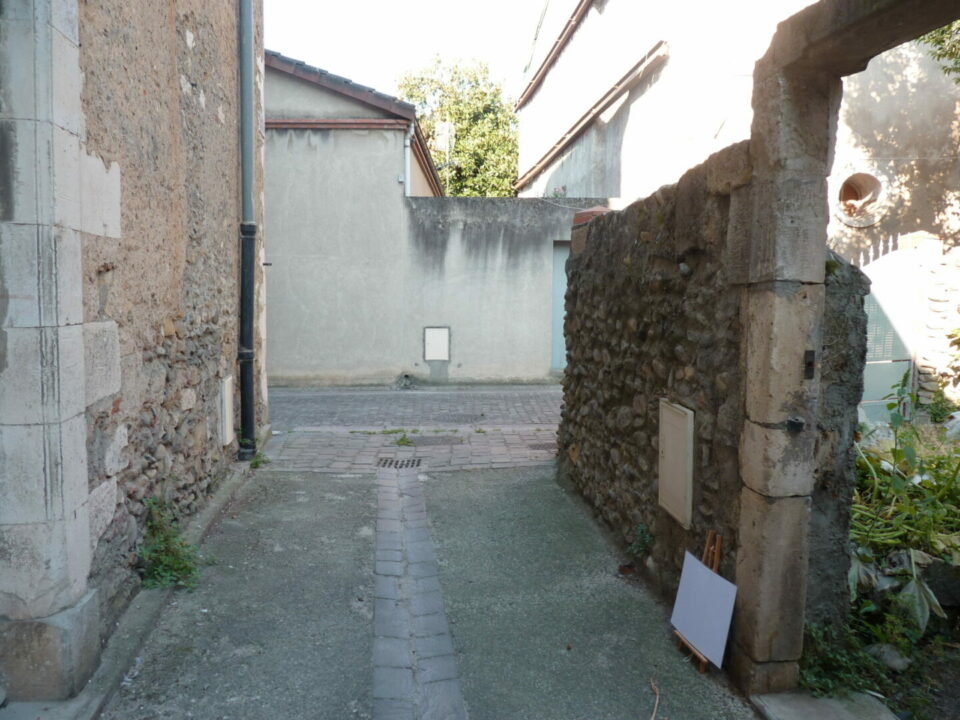 Passage étroit entre murs en pierre dans le Cœur de Garonne