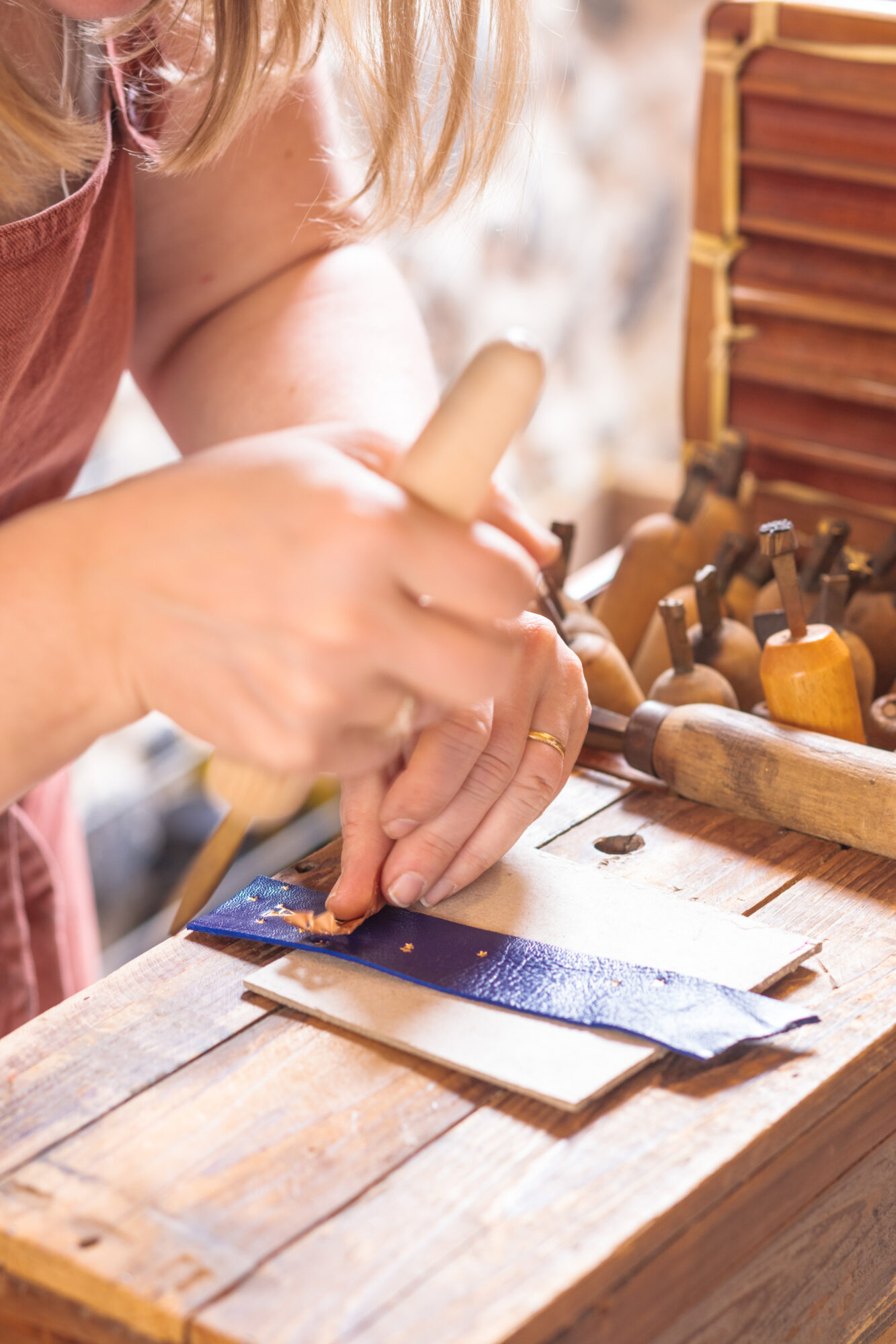 Artisane travaillant le cuir avec des outils de maroquinerie