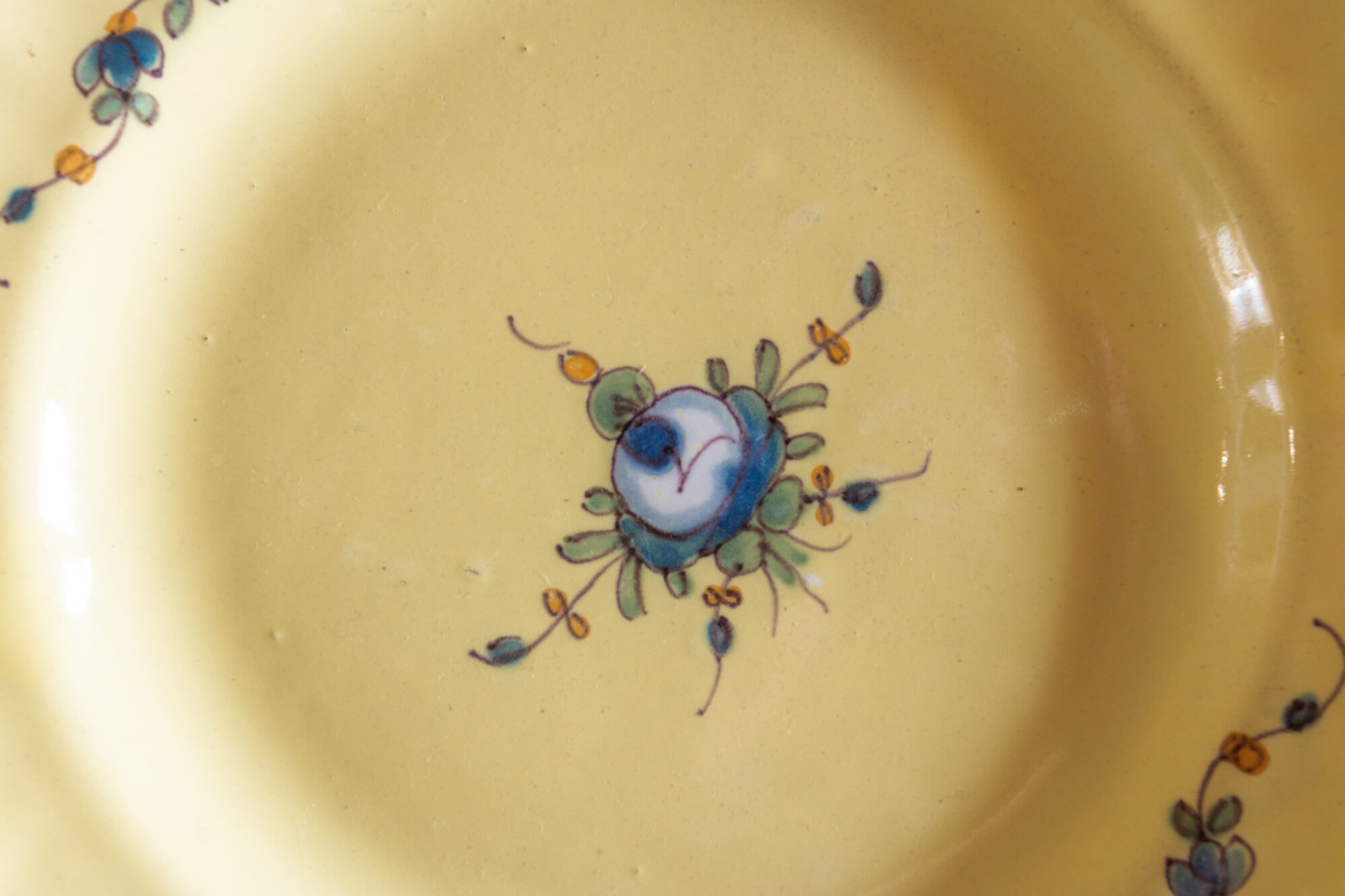 Décor floral peint sur faïence jaune ancienne