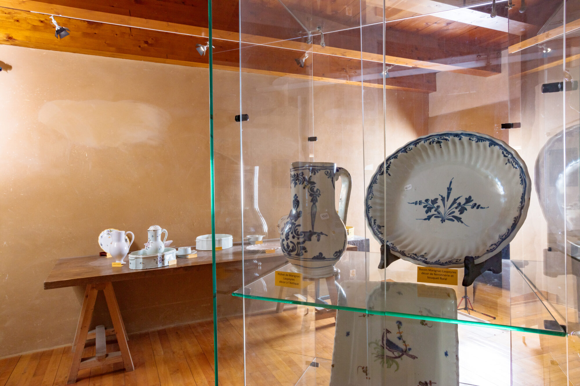 Vitrine de faïences anciennes avec assiette et pichet décorés bleu et blanc