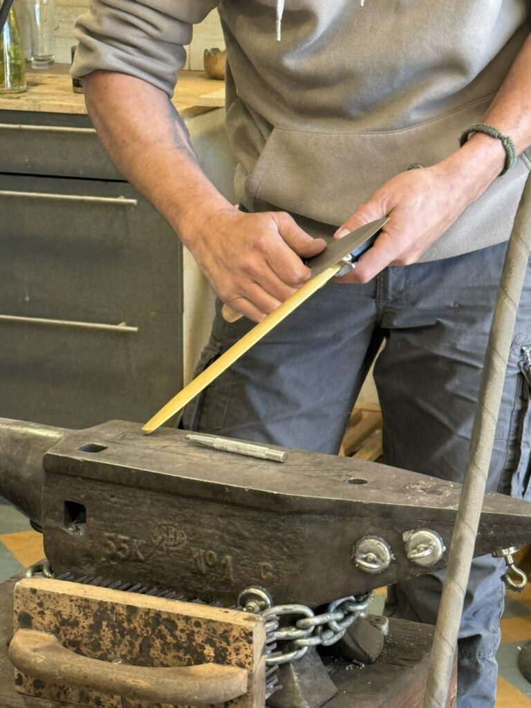 Artisan affûtant une lame sur une enclume, Office de Tourisme Cœur de Garonne
