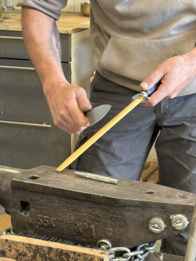 Artisan affûtant un outil sur une enclume, Office de Tourisme Cœur de Garonne