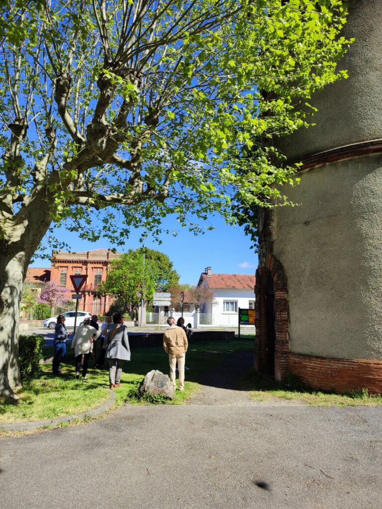 Visiteurs devant l’Office de Tourisme Cœur de Garonne sous un arbre