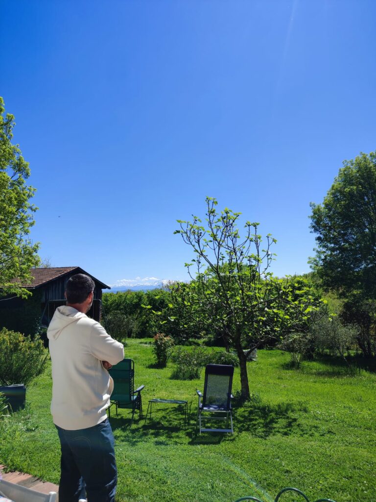 Homme dans un jardin face aux montagnes, Office de Tourisme Cœur de Garonne