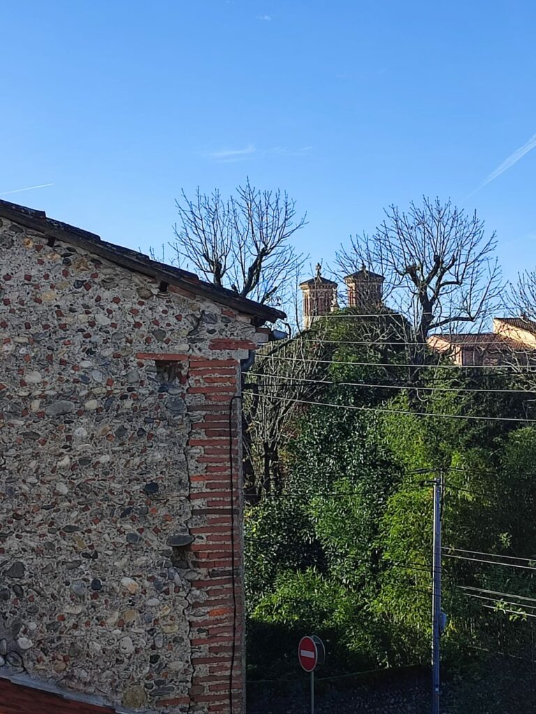 Façade en galets et briques avec clochers d’église à l’arrière-plan