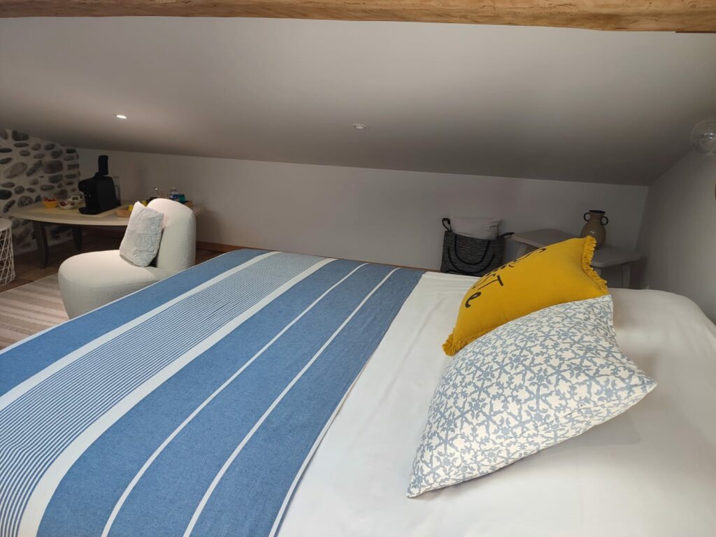 Chambre mansardée avec lit double et coin détente cosy
