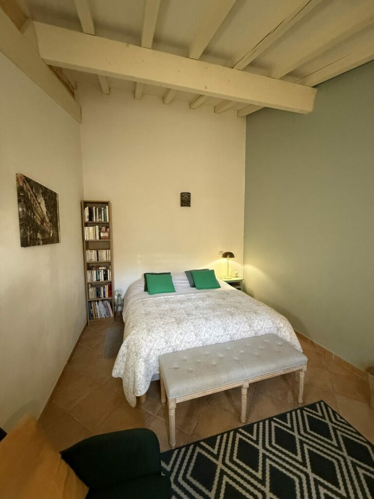 Chambre avec lit double, banc et bibliothèque, Office de Tourisme Cœur de