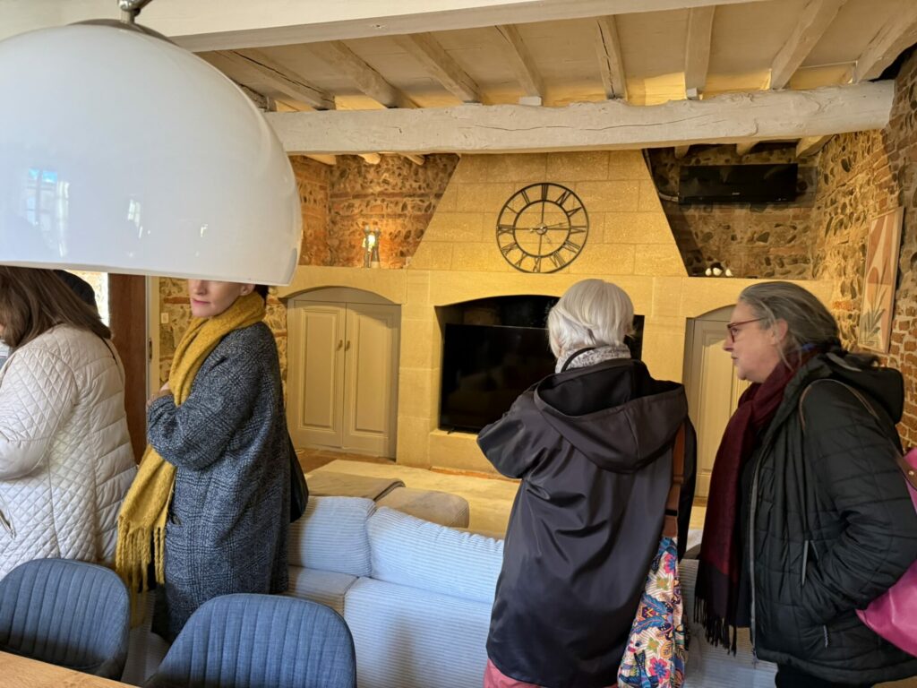 Visiteurs dans un salon avec grande cheminée, Office de Tourisme Cœur de Garonne