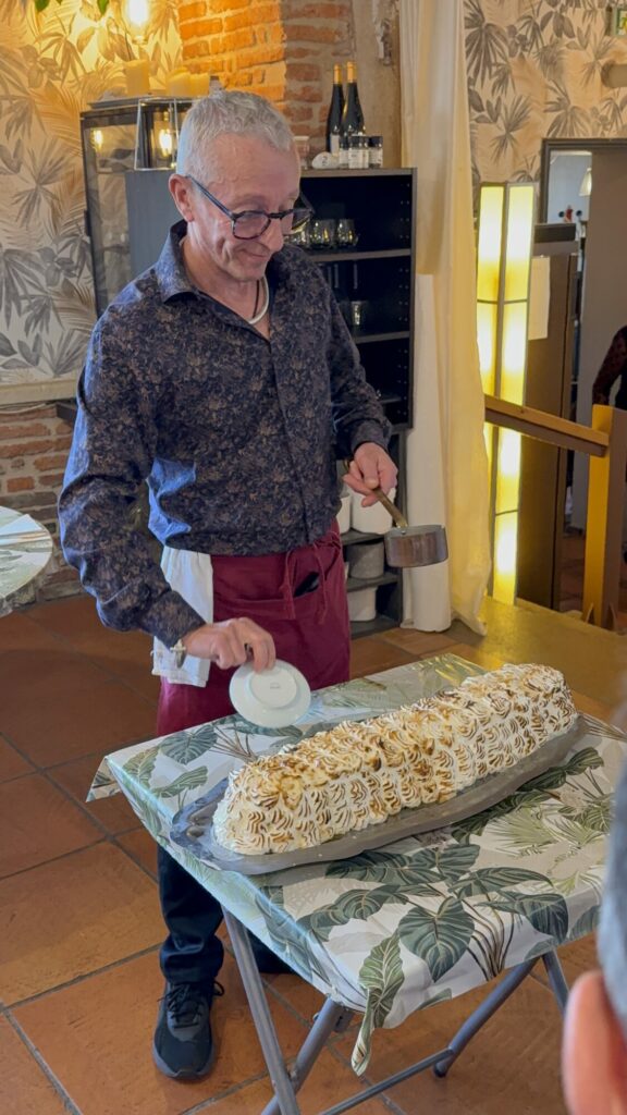 Serveur présentant un dessert meringué flambé en salle de restaurant