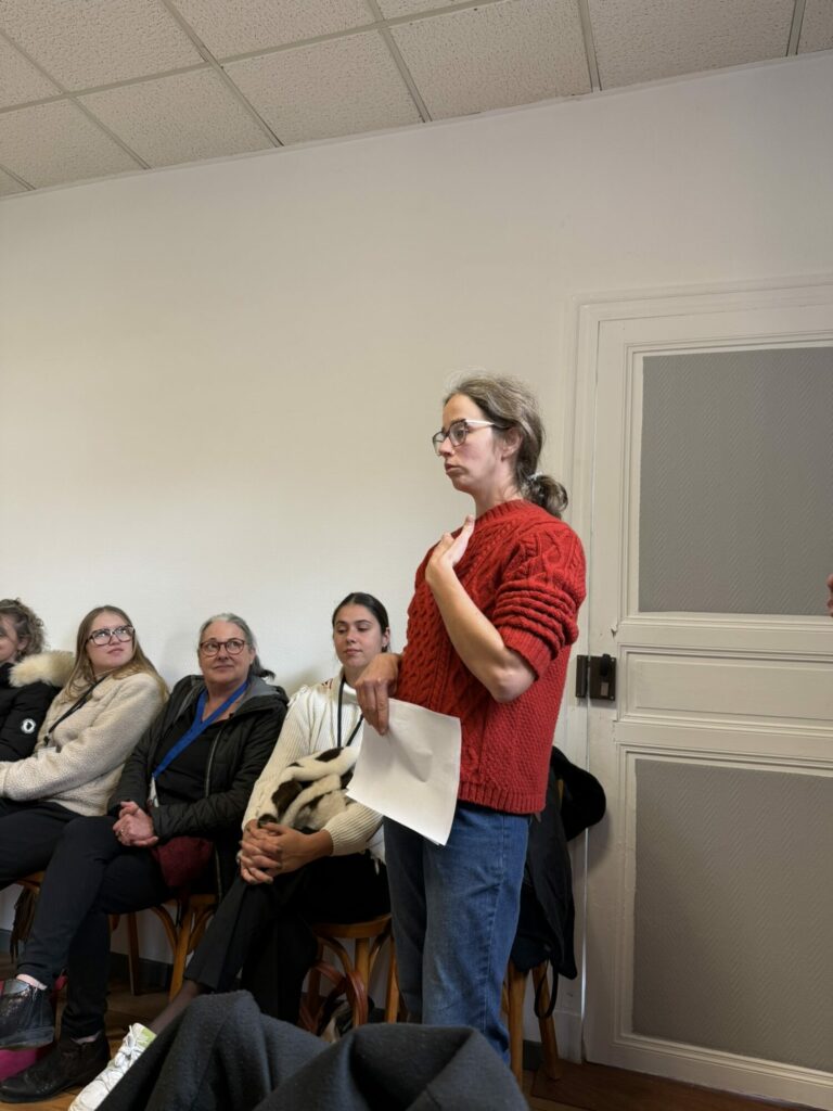 Intervenante debout face à un groupe lors d’une réunion participative