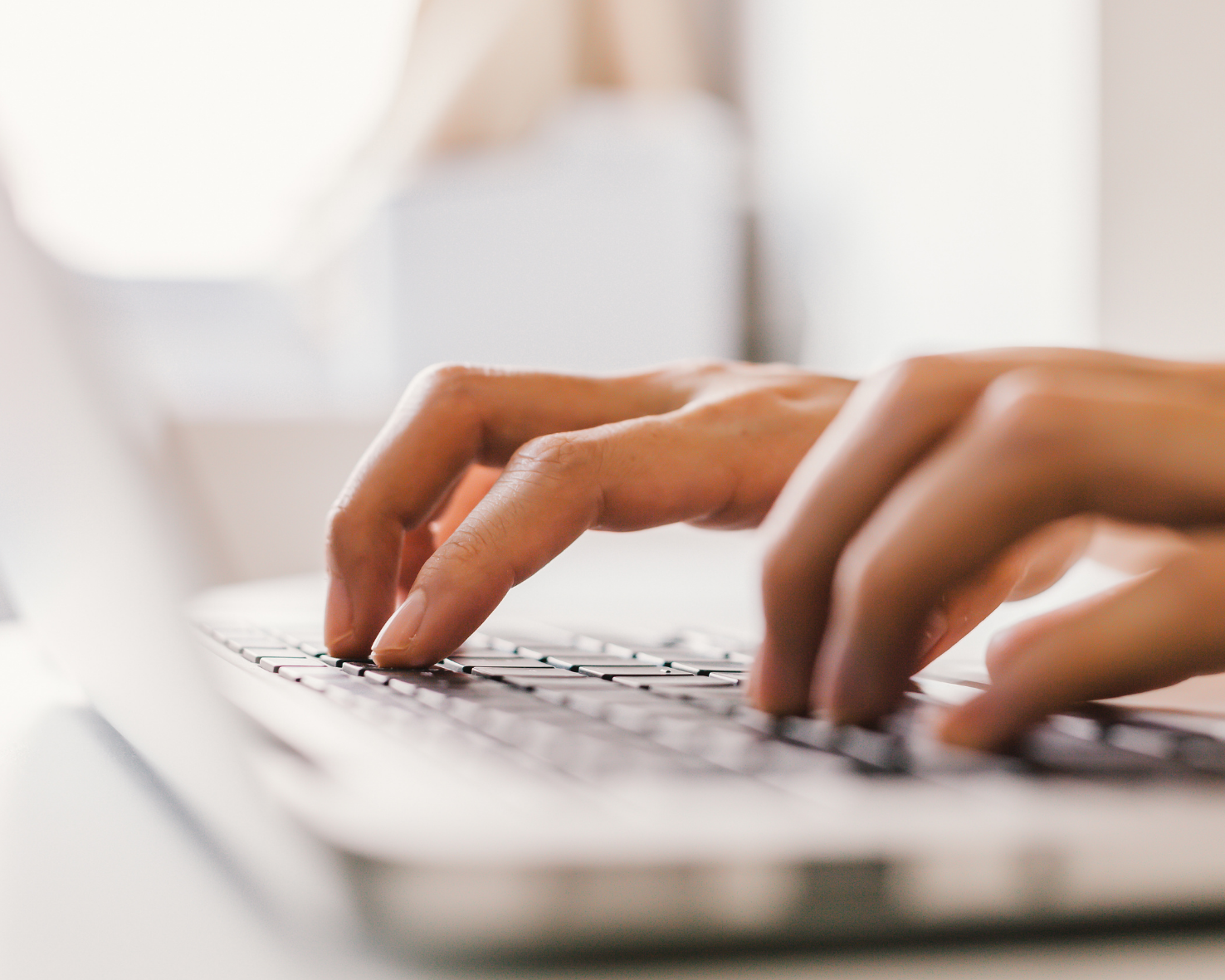 Mains tapant sur un clavier d’ordinateur pour l’Office de Tourisme Cœur de