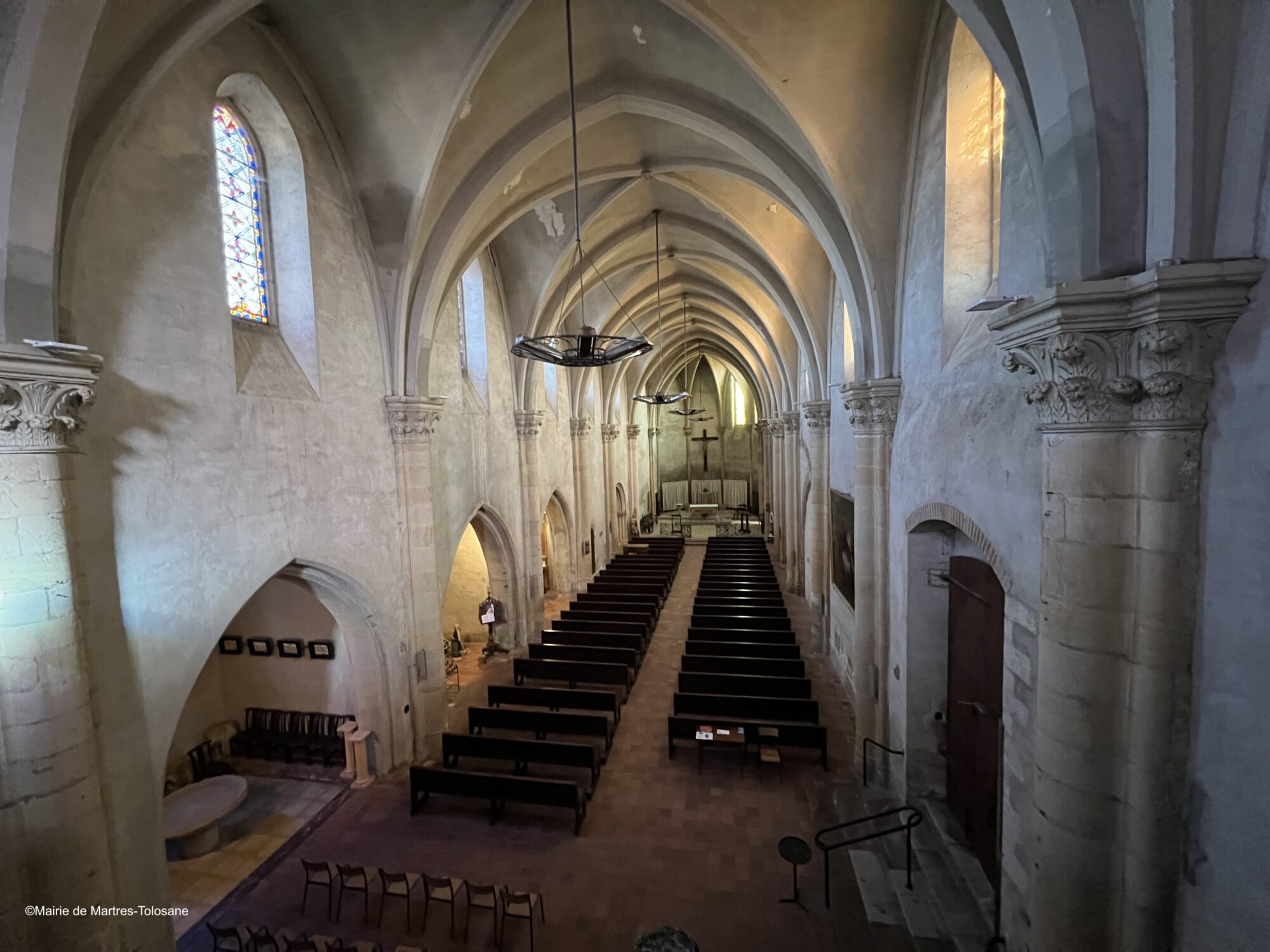 Intérieur d’église gothique avec nef, bancs et autel à Martres-Tolosane