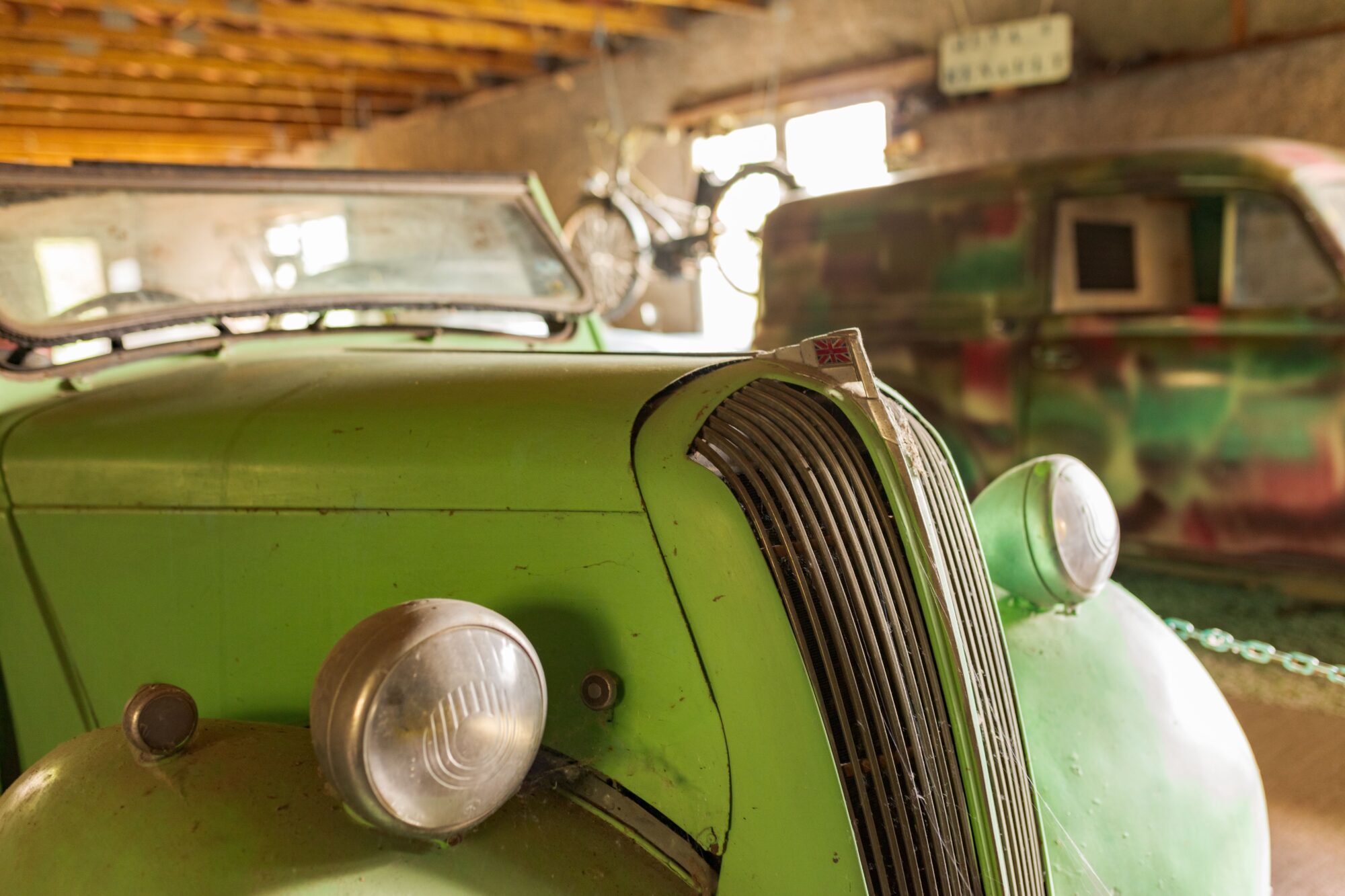 Avant d'une voiture ancienne verte dans l'Office de Tourisme Cœur de Garonne