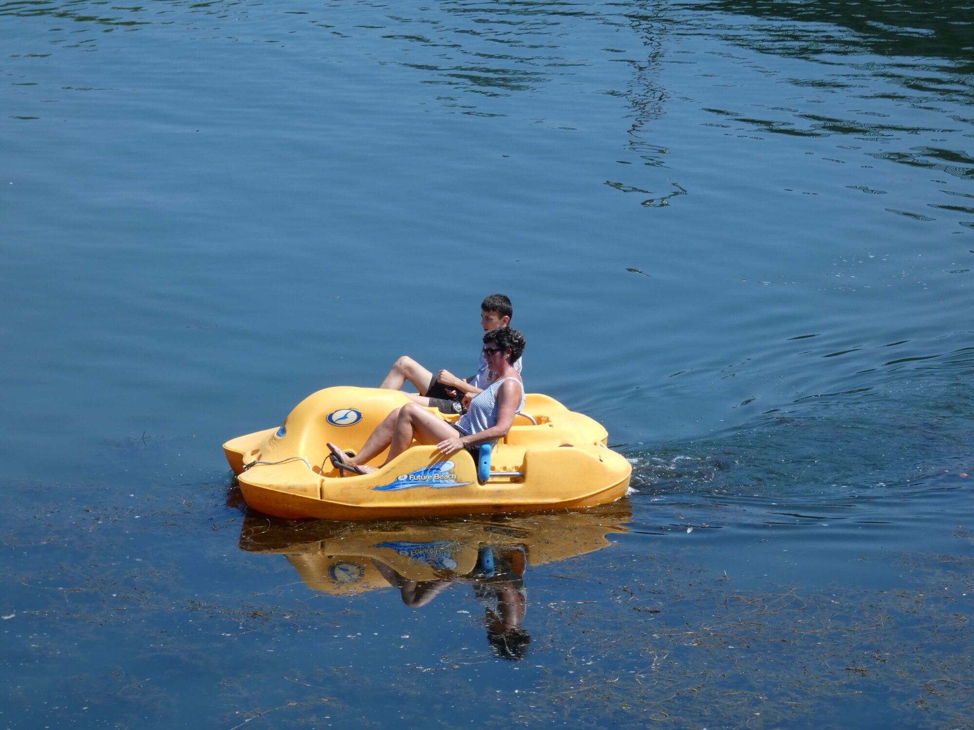 Deux personnes sur un pédalo jaune sur l’eau