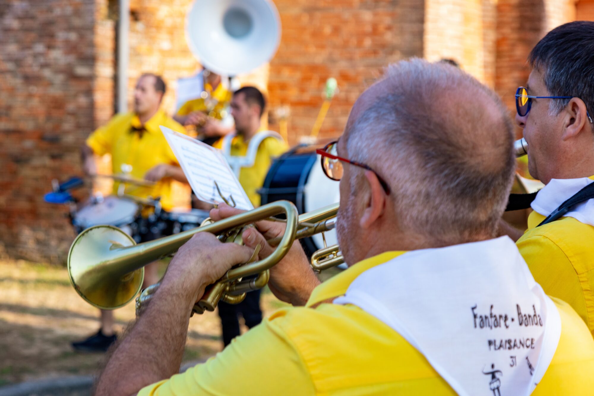 Musiciens de fanfare en chemises jaunes jouant des cuivres et percussions