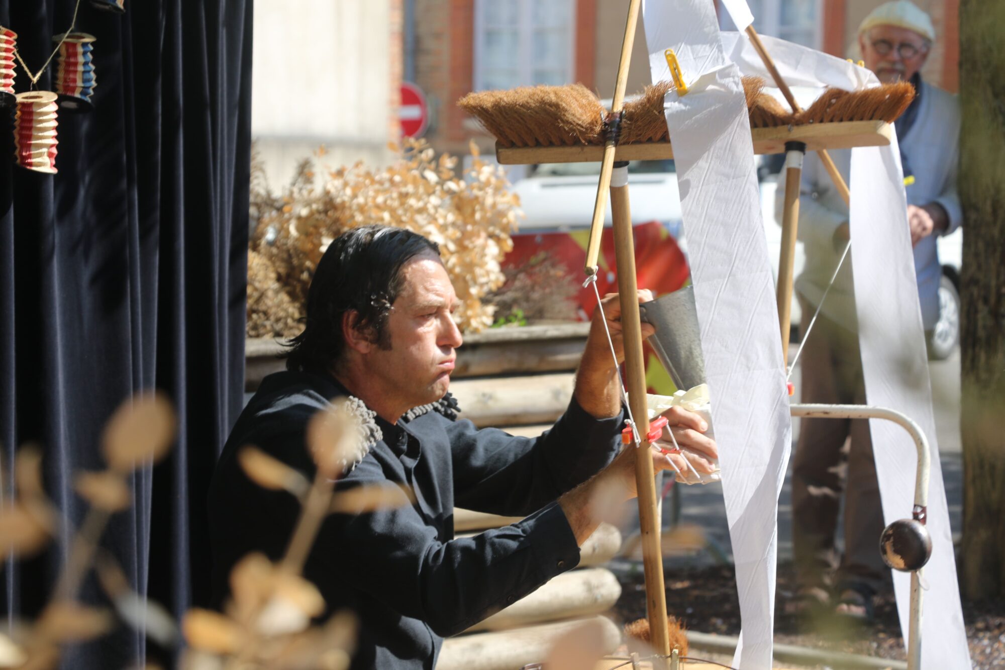 Artiste manipulant une machine artisanale lors d'un spectacle de rue