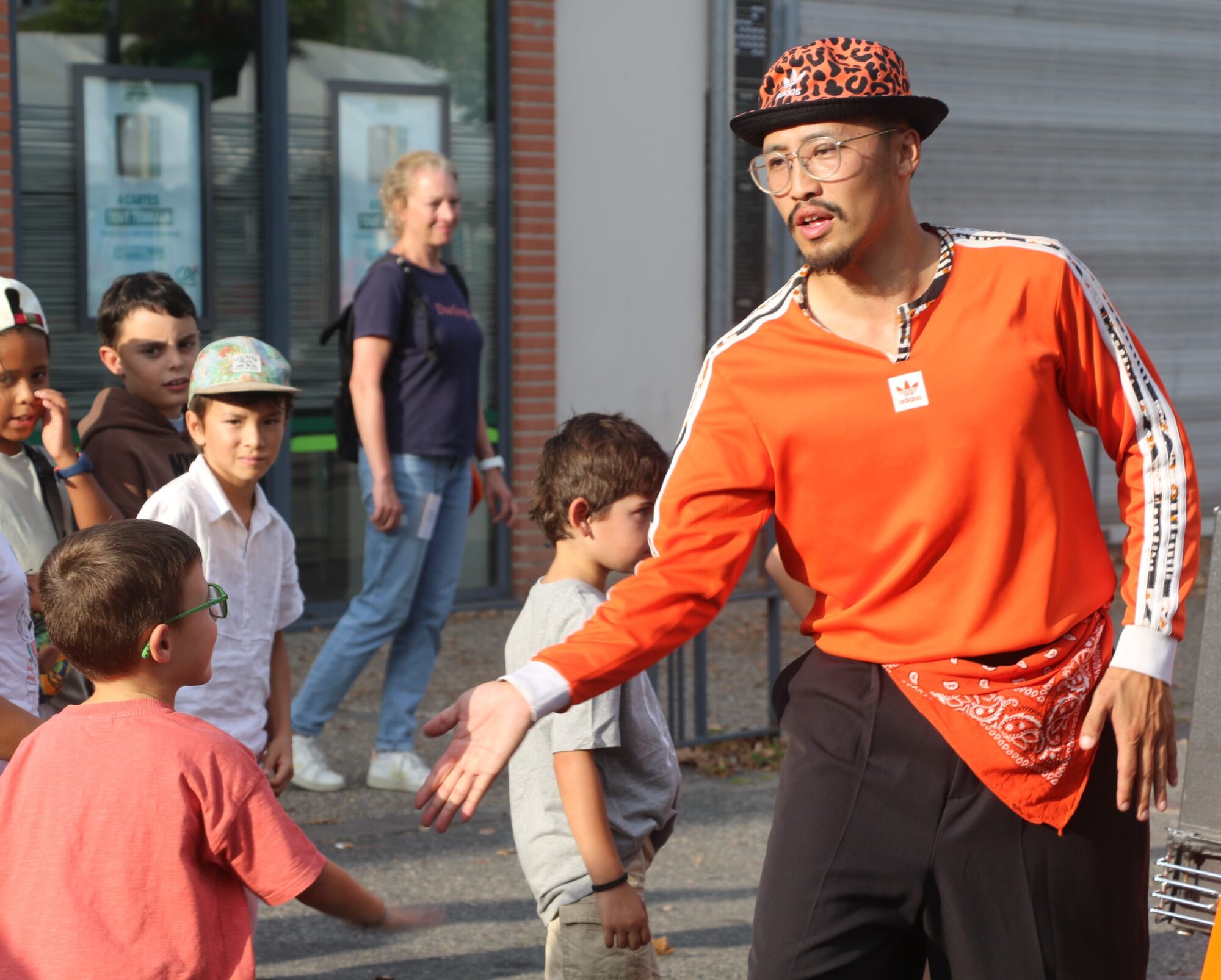 Animateur en tenue orange guidant des enfants à l’Office de Tourisme Cœur de