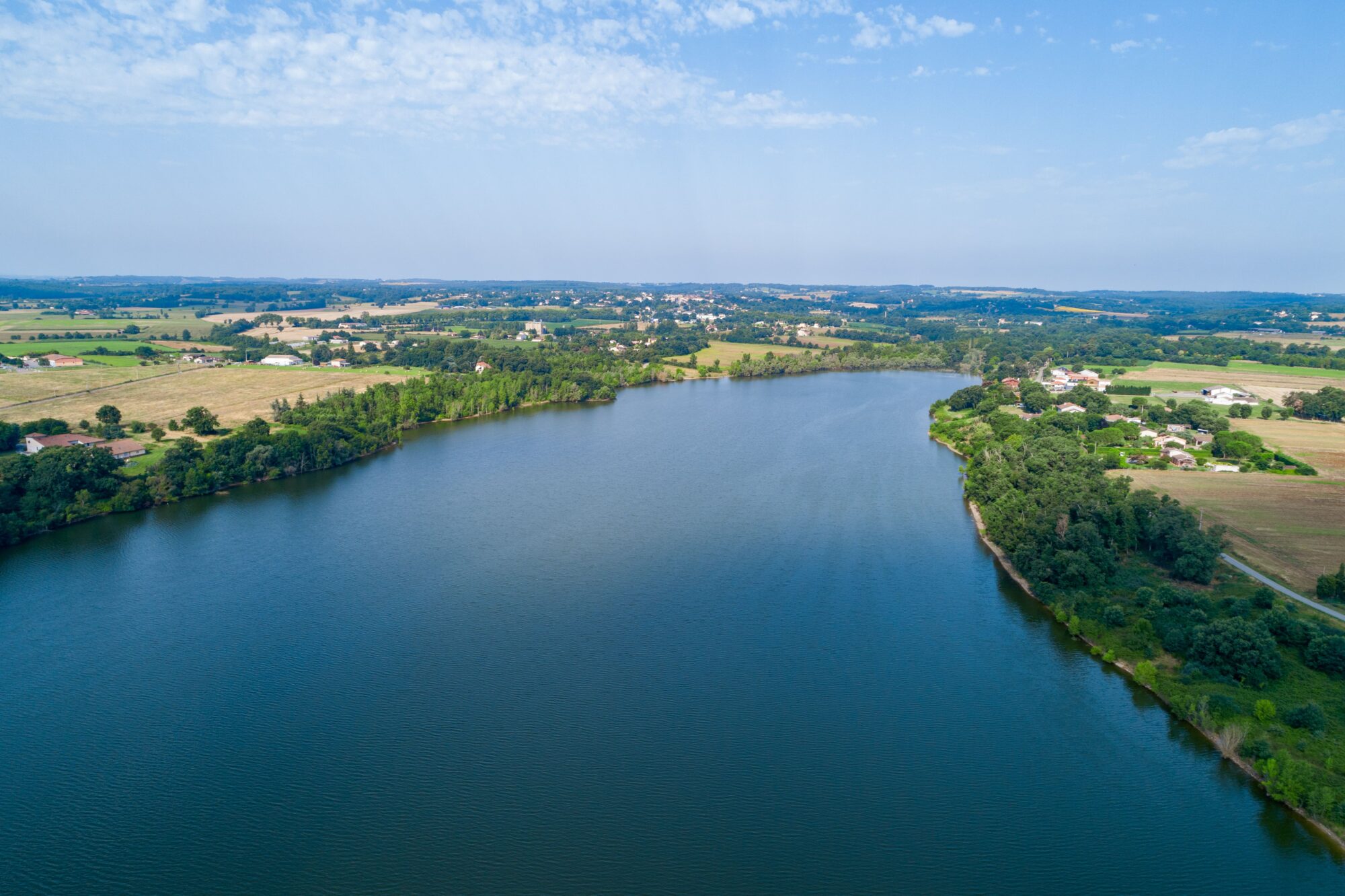 Vue aérienne d'un lac bordé de bois et de villages en Cœur de Garonne