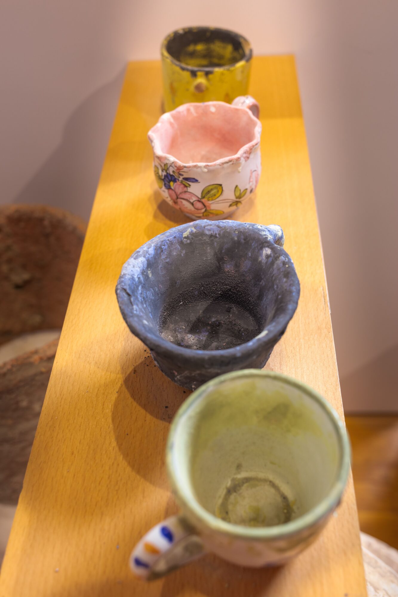 Céramiques artisanales colorées : bols et tasses exposés sur une étagère