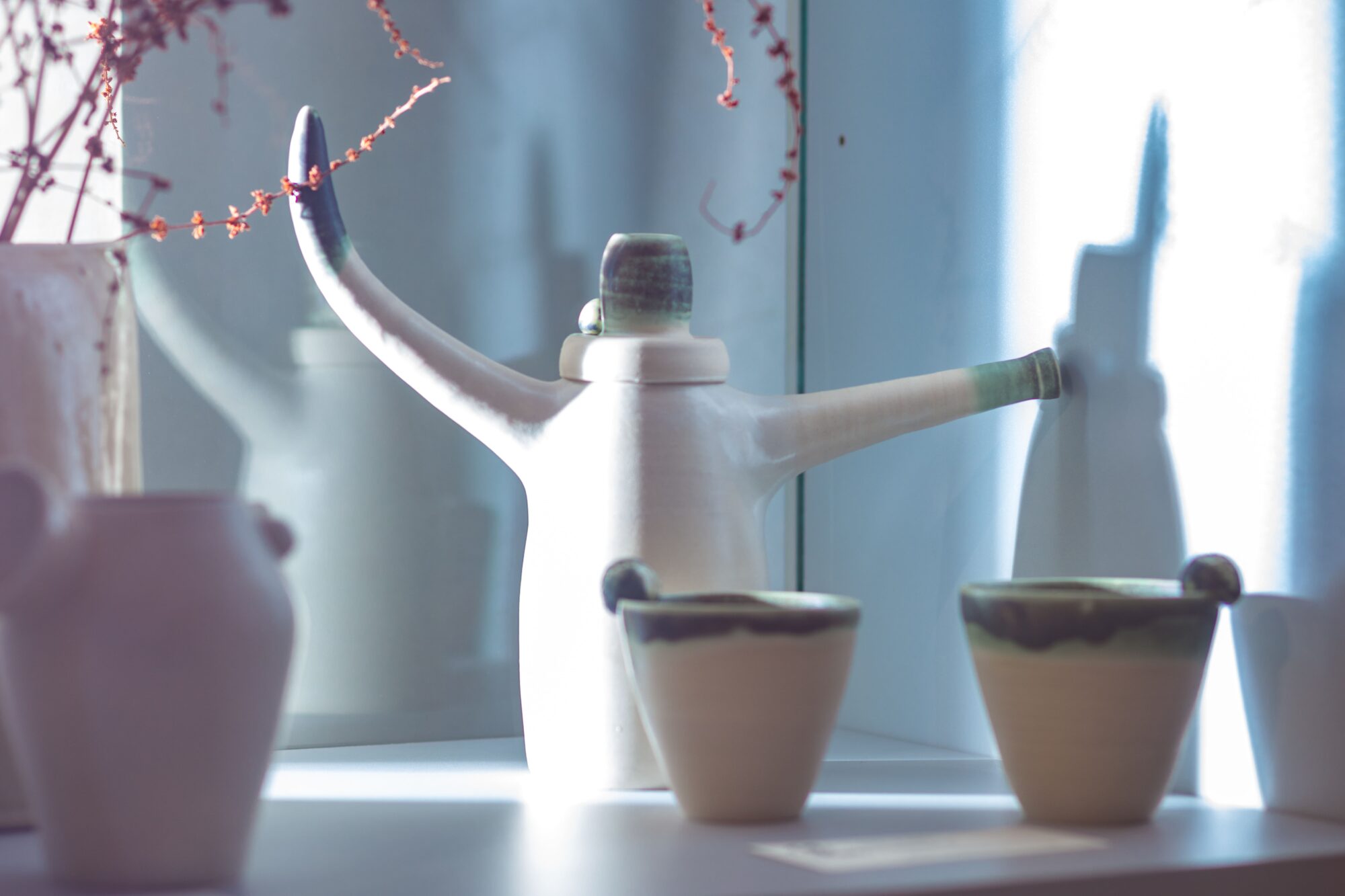 Arrosoir en céramique blanche et deux gobelets artisanaux
