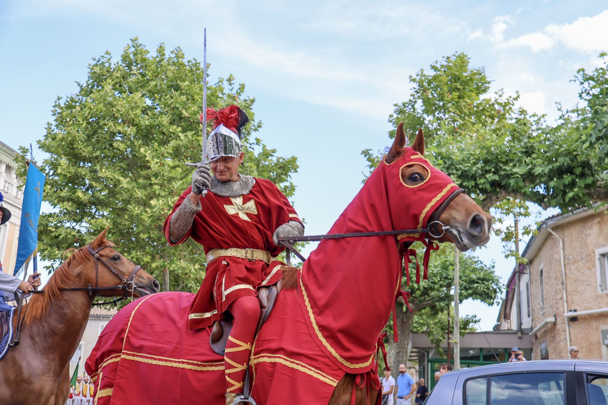 Chevalier en costume rouge à cheval, fête médiévale Cœur de Garonne