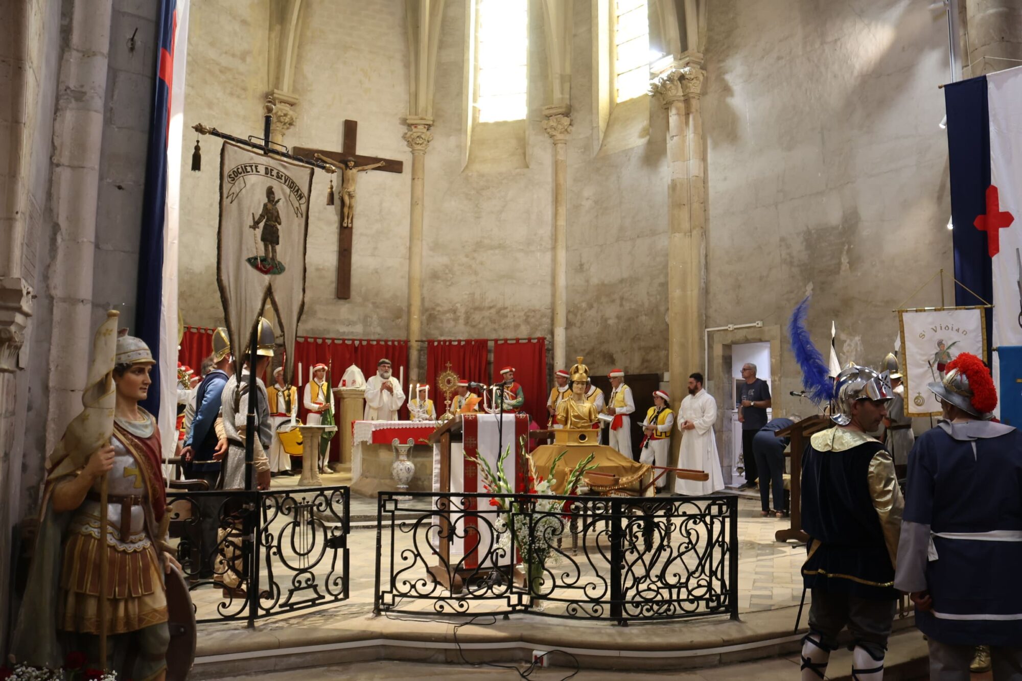 Cérémonie religieuse avec procession en costumes dans une église