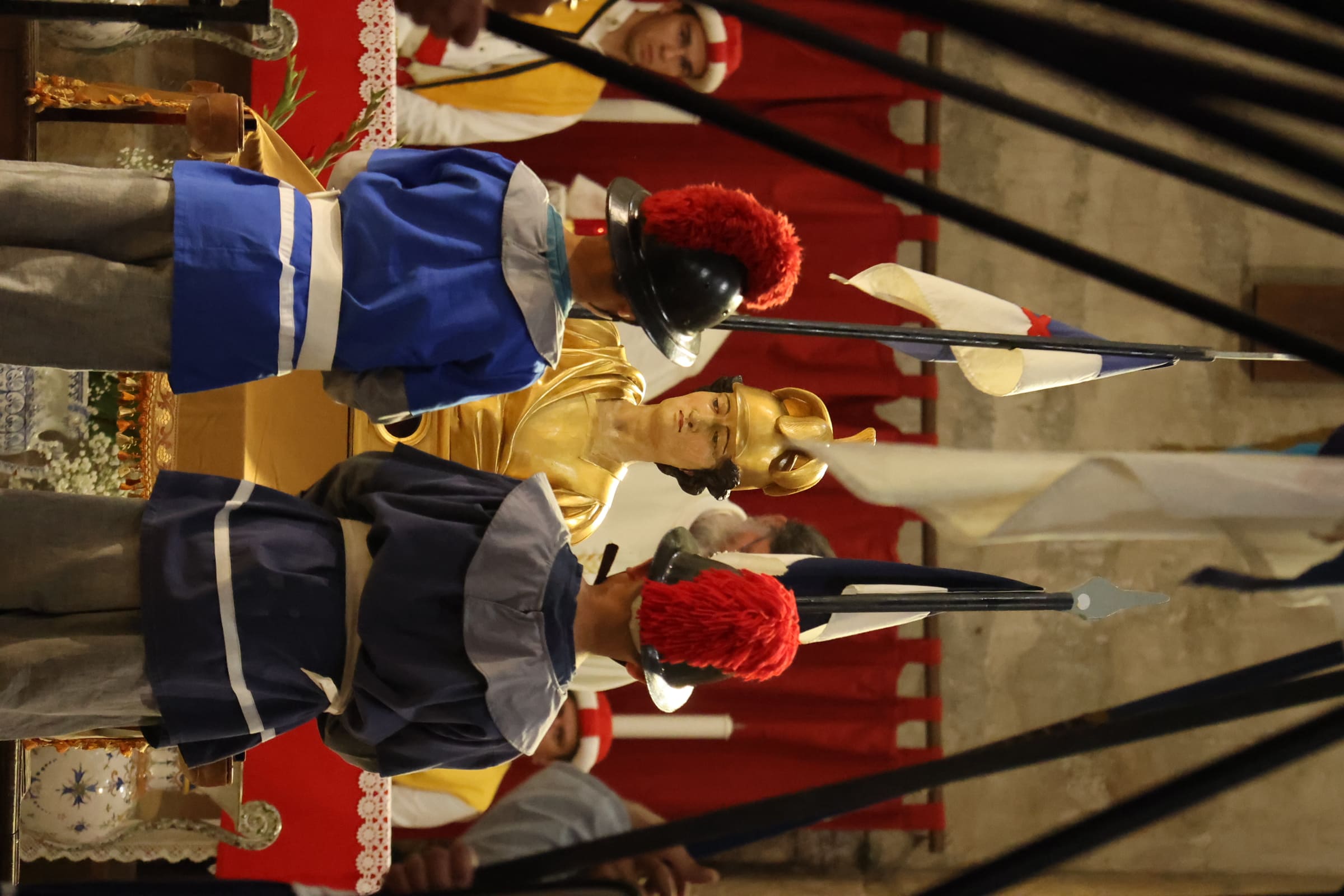 Gardes en uniforme autour d'une statue dorée lors d'une cérémonie médiévale