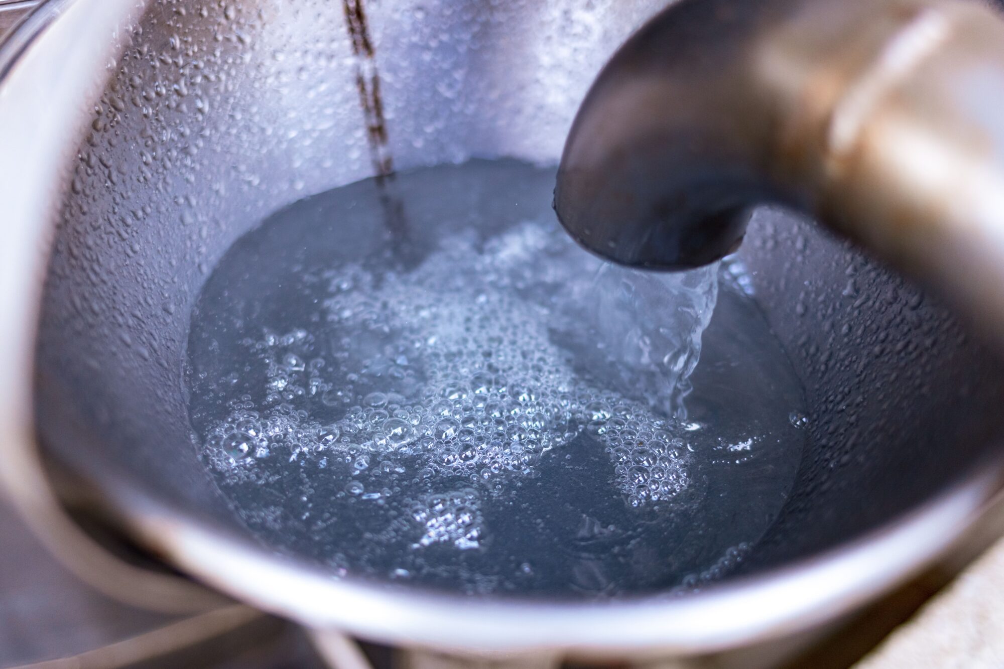 Eau de source coulant d'un robinet dans un seau métallique
