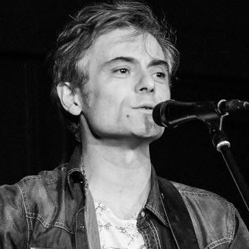 Chanteur au micro sur scène, portrait en noir et blanc
