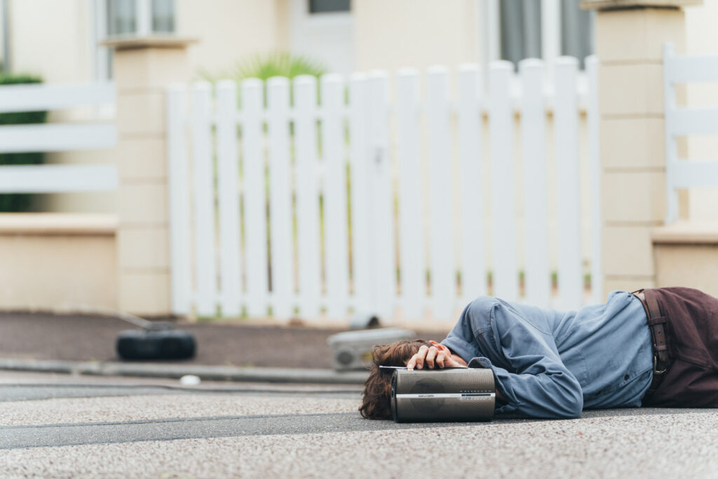 Personne allongée au sol près d’une radio portable