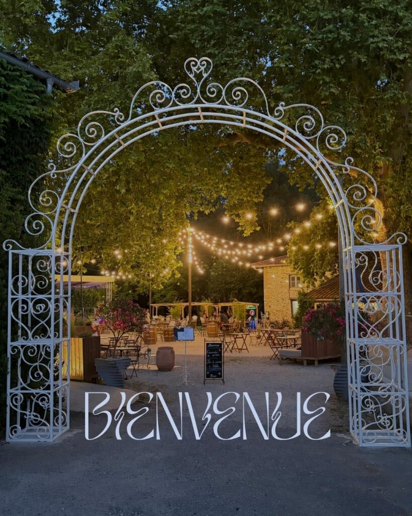 Arche en fer forgé à l’entrée d’une terrasse éclairée, bienvenue